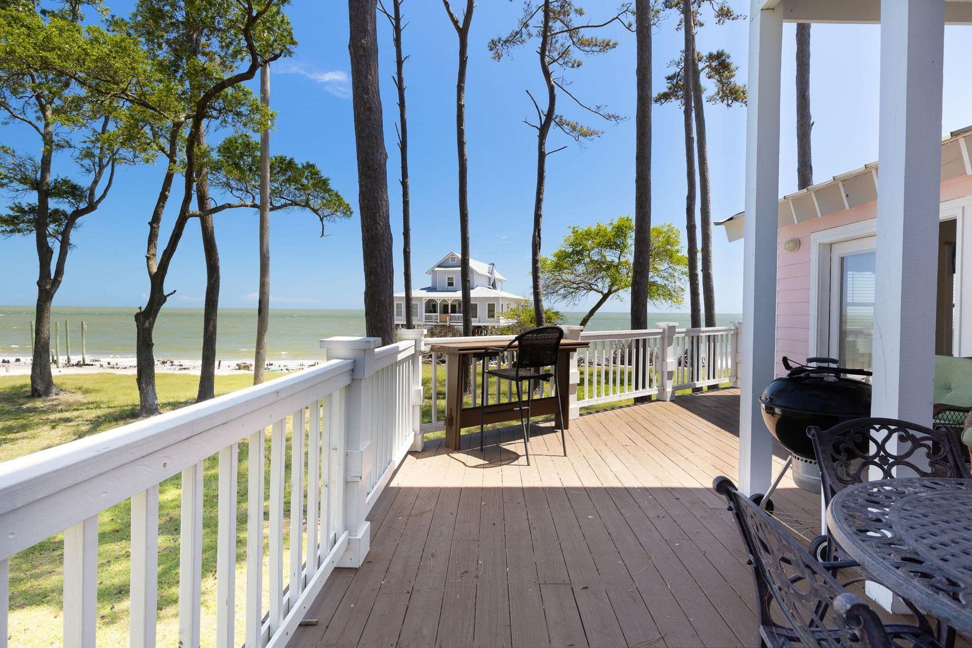 A deck with a table and chairs overlooking the ocean