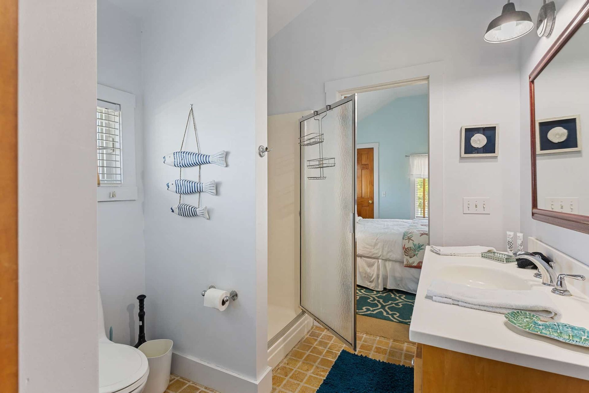 A bathroom with a toilet , sink , mirror and shower.