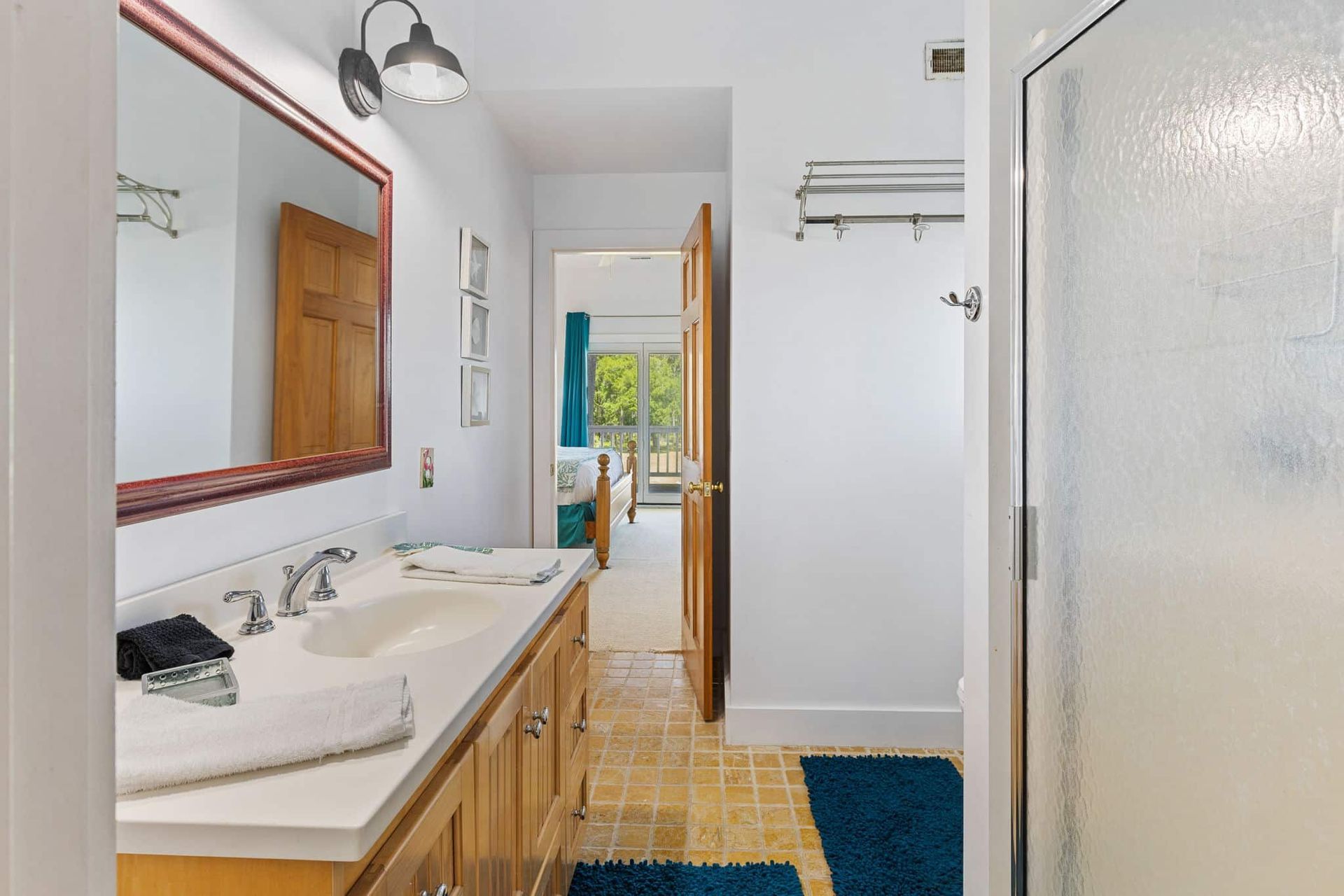 A bathroom with two sinks , a mirror , and a walk in shower.