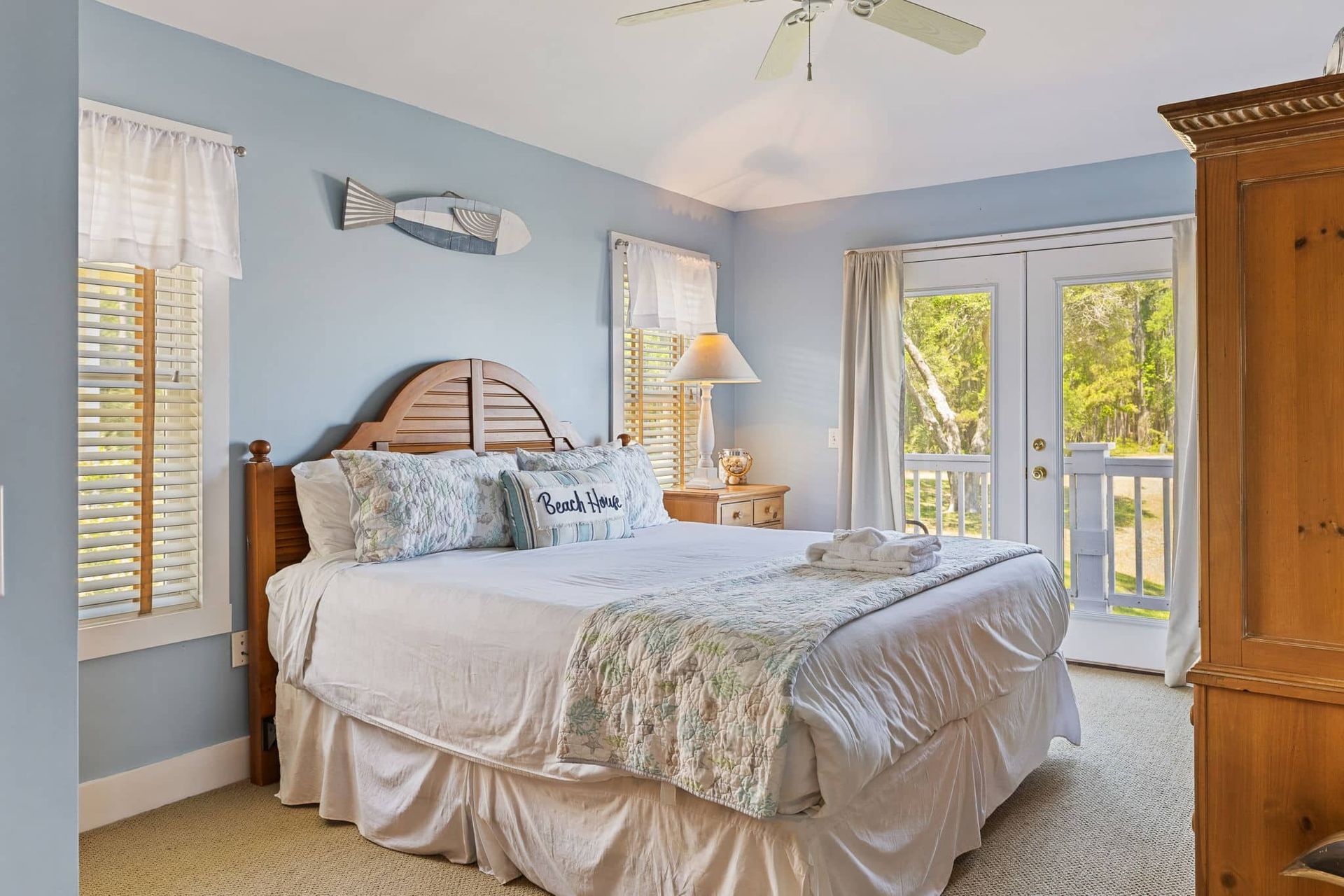 A bedroom with a king size bed and a ceiling fan.