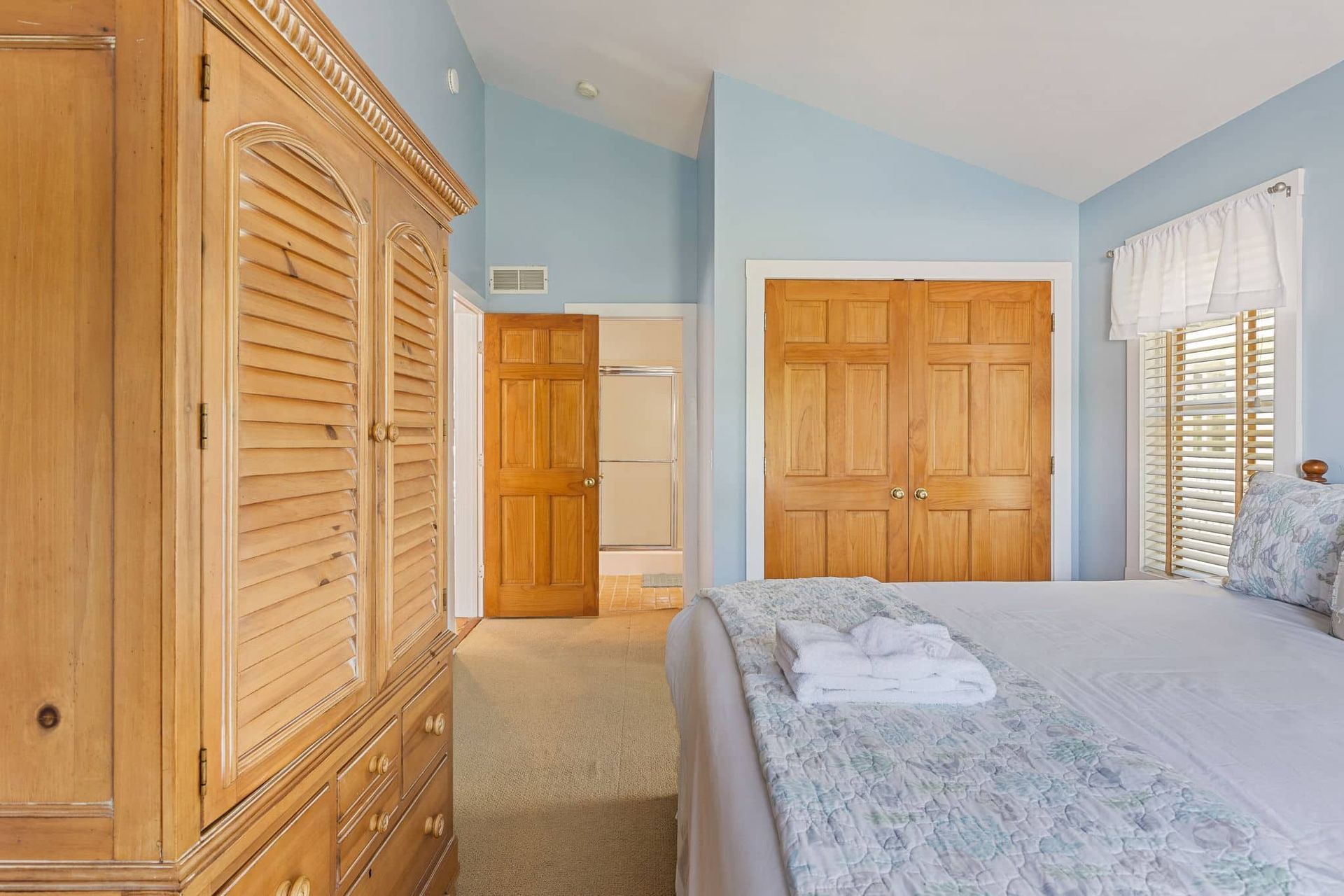 A bedroom with a bed , dresser , and closet.