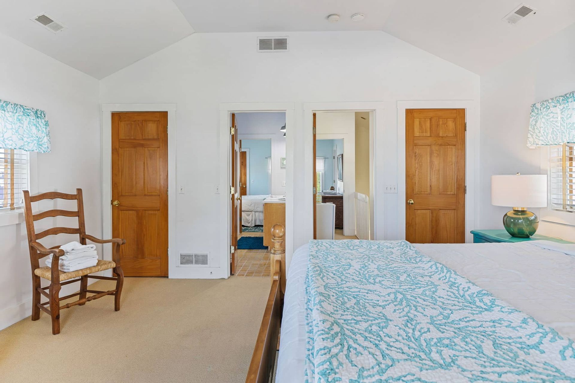 A bedroom with a king size bed , a chair , and a lamp.