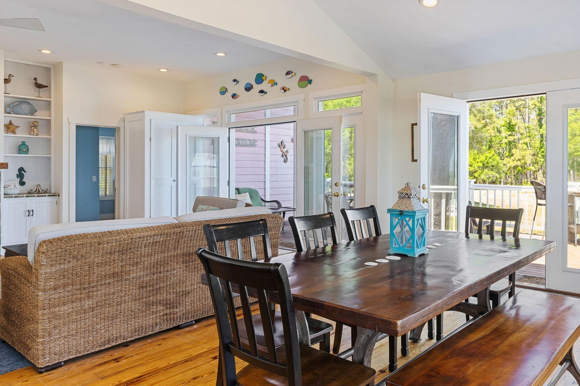 A dining room table with chairs and a bench in a living room.