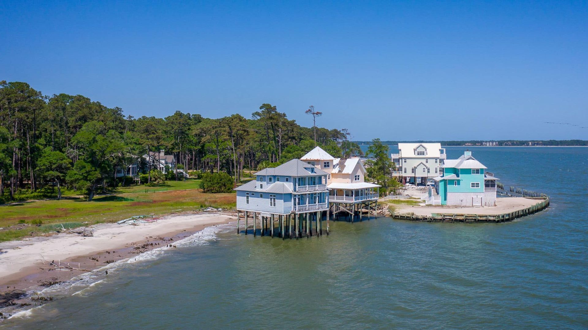 An aerial view of a house on stilts in the middle of a body of water.