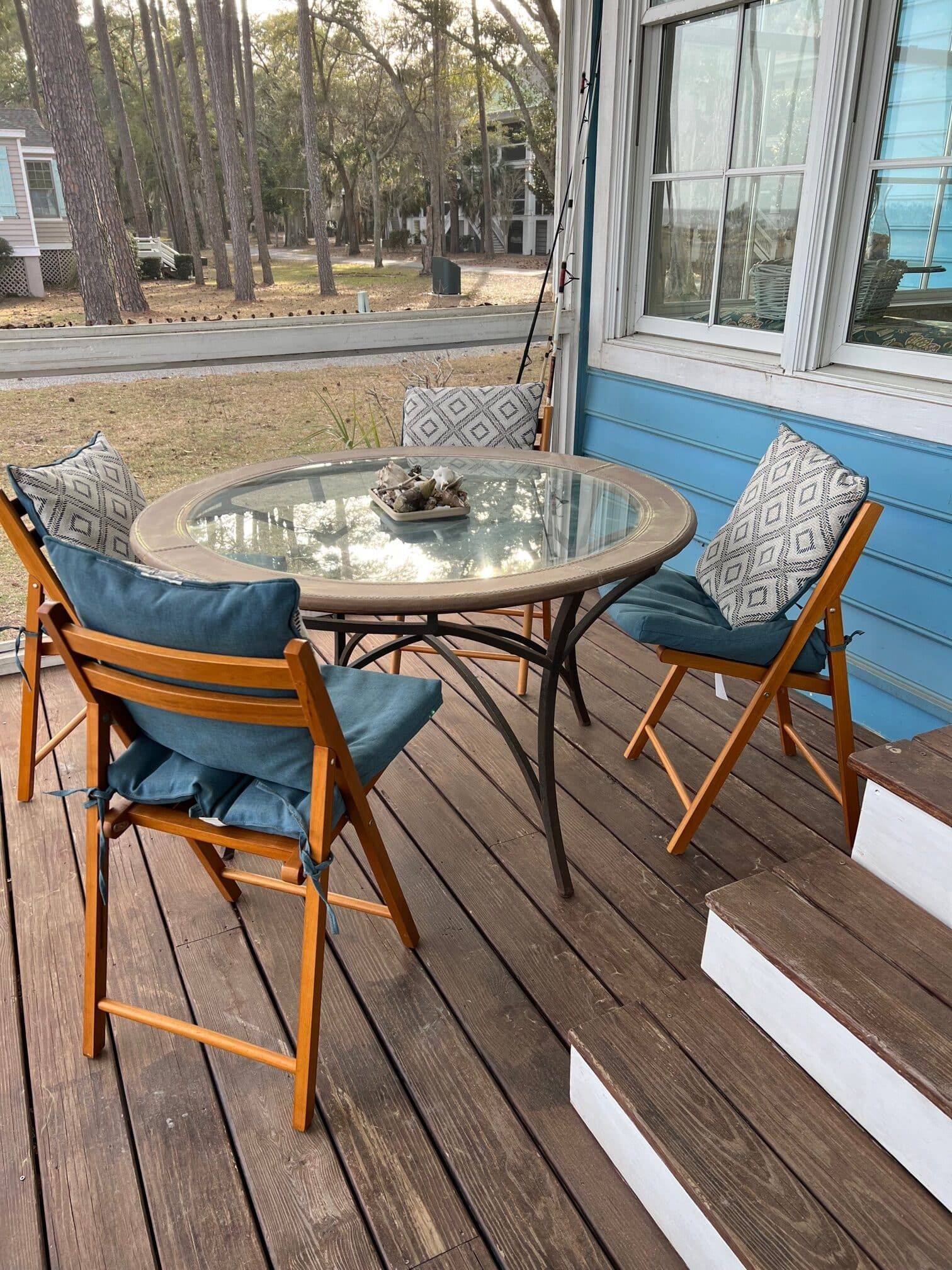 A wooden deck with a table and chairs on it.