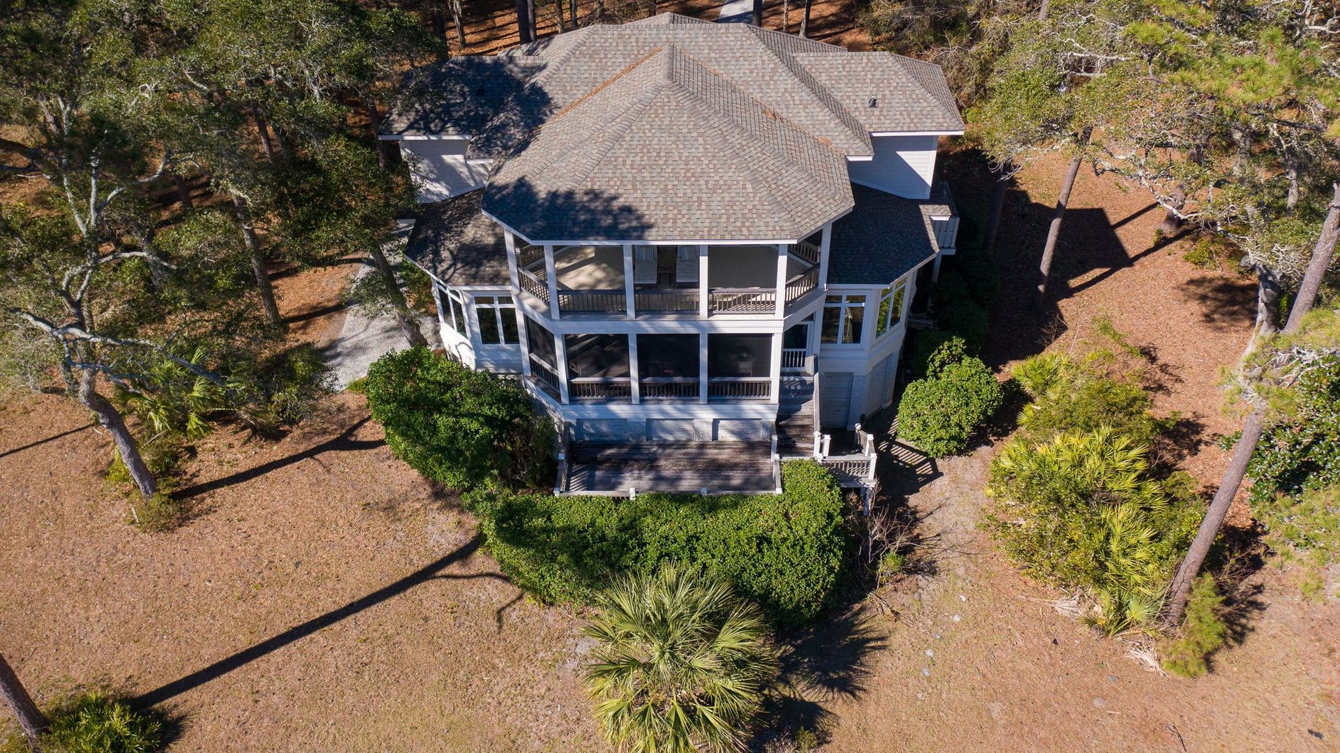 An aerial view of a large white house surrounded by trees.