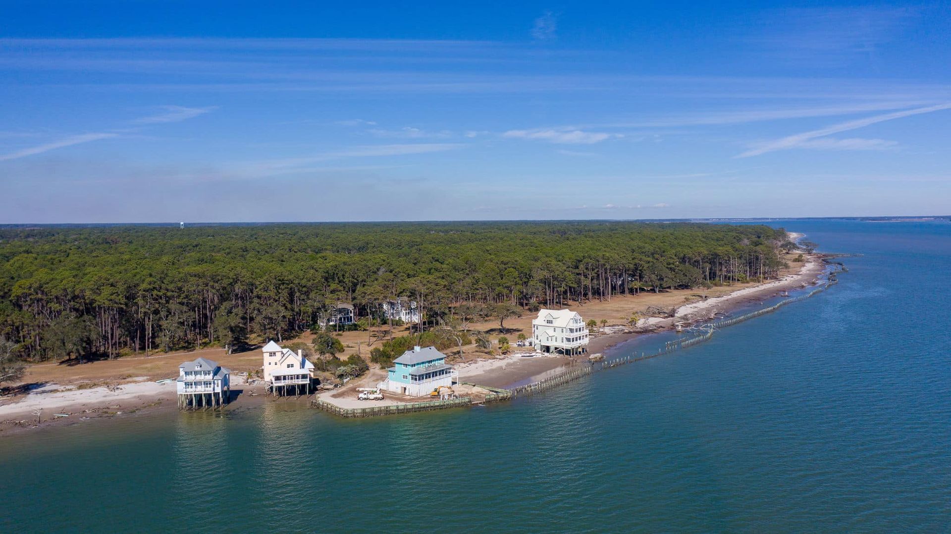 An aerial view of a small island in the middle of the ocean surrounded by trees.