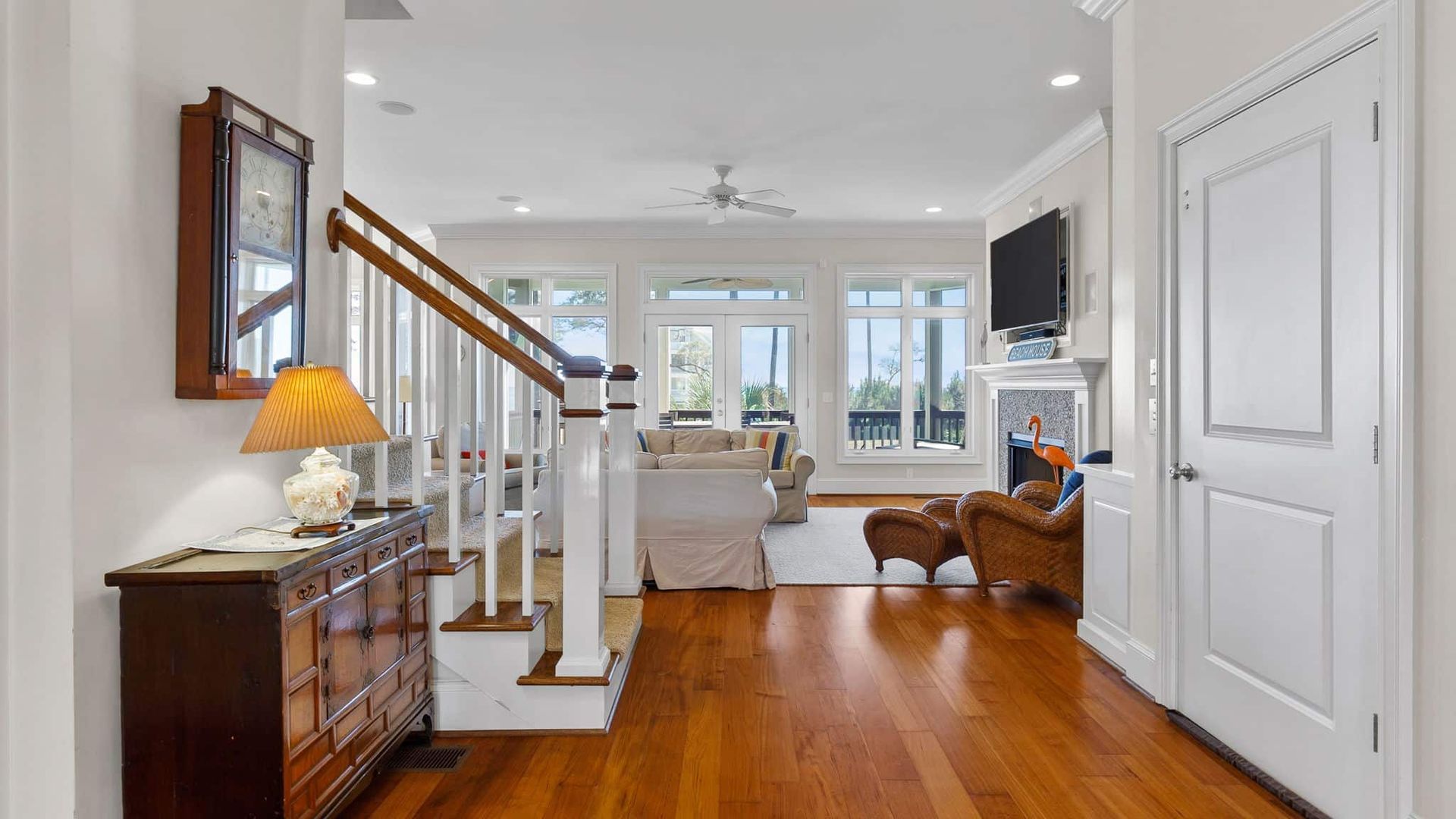 A living room with hardwood floors and a staircase leading to the second floor.