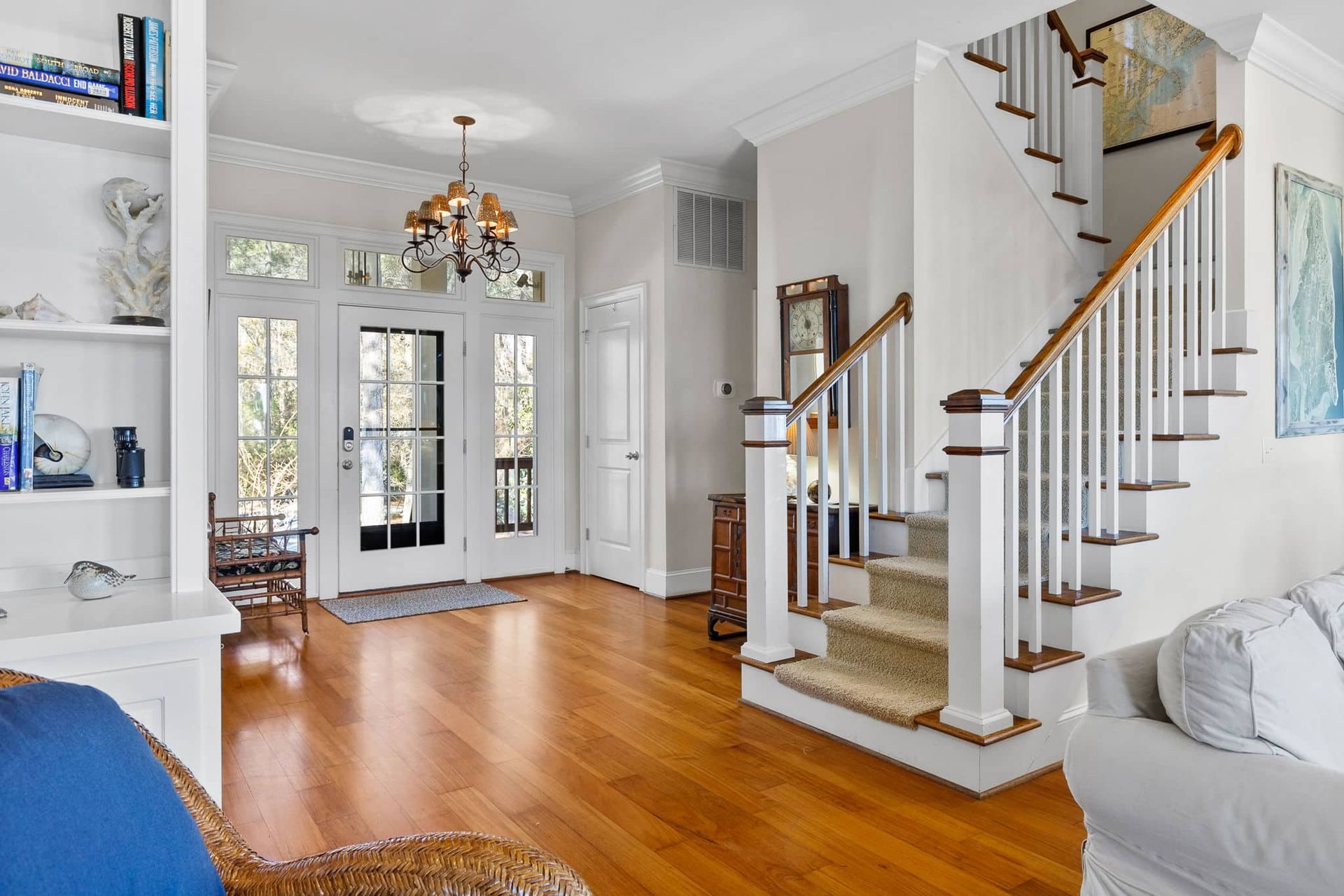 A living room with hardwood floors and stairs leading up to the second floor.