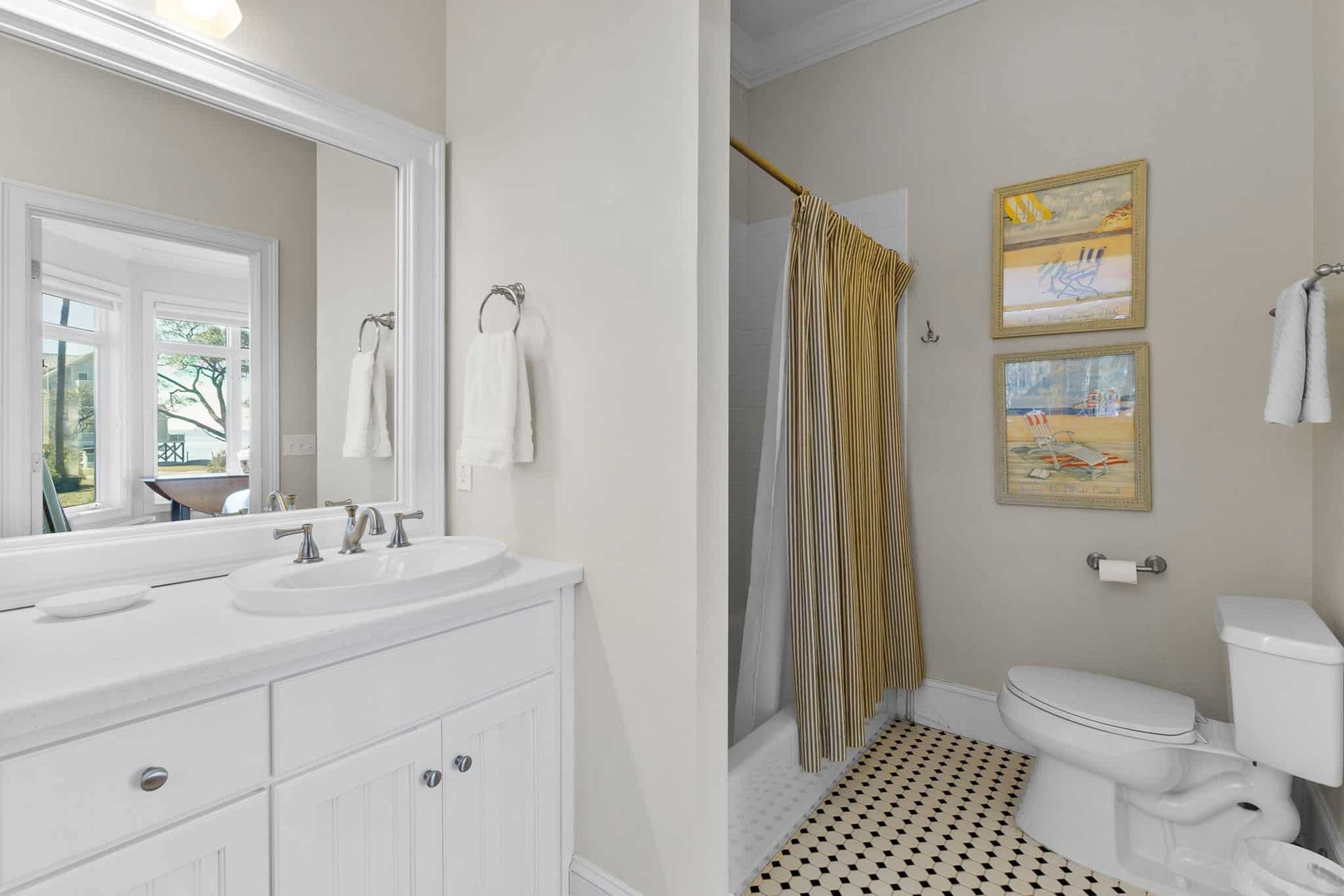 A bathroom with a sink , toilet , shower and mirror.