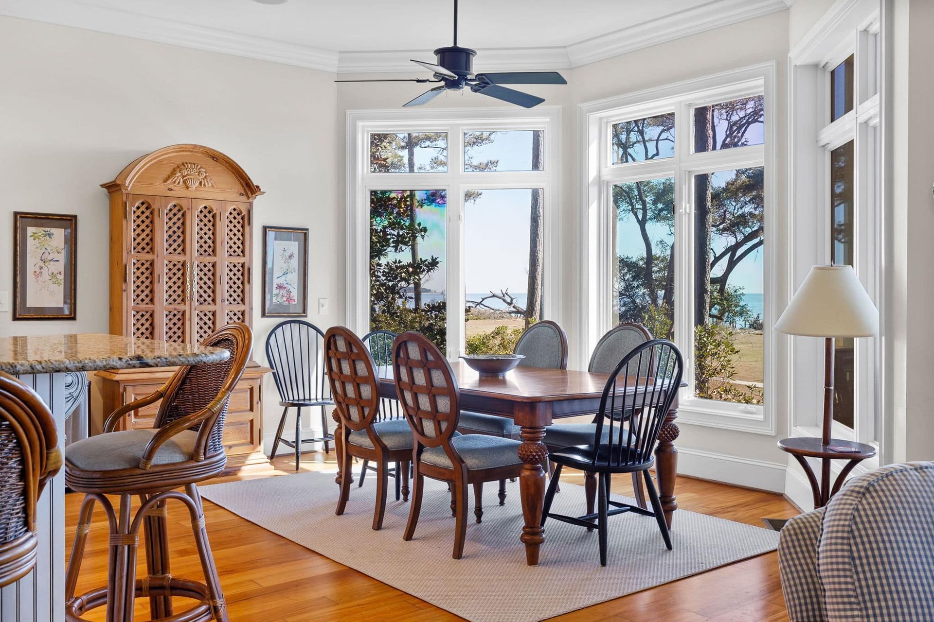 A dining room with a table and chairs and a ceiling fan.