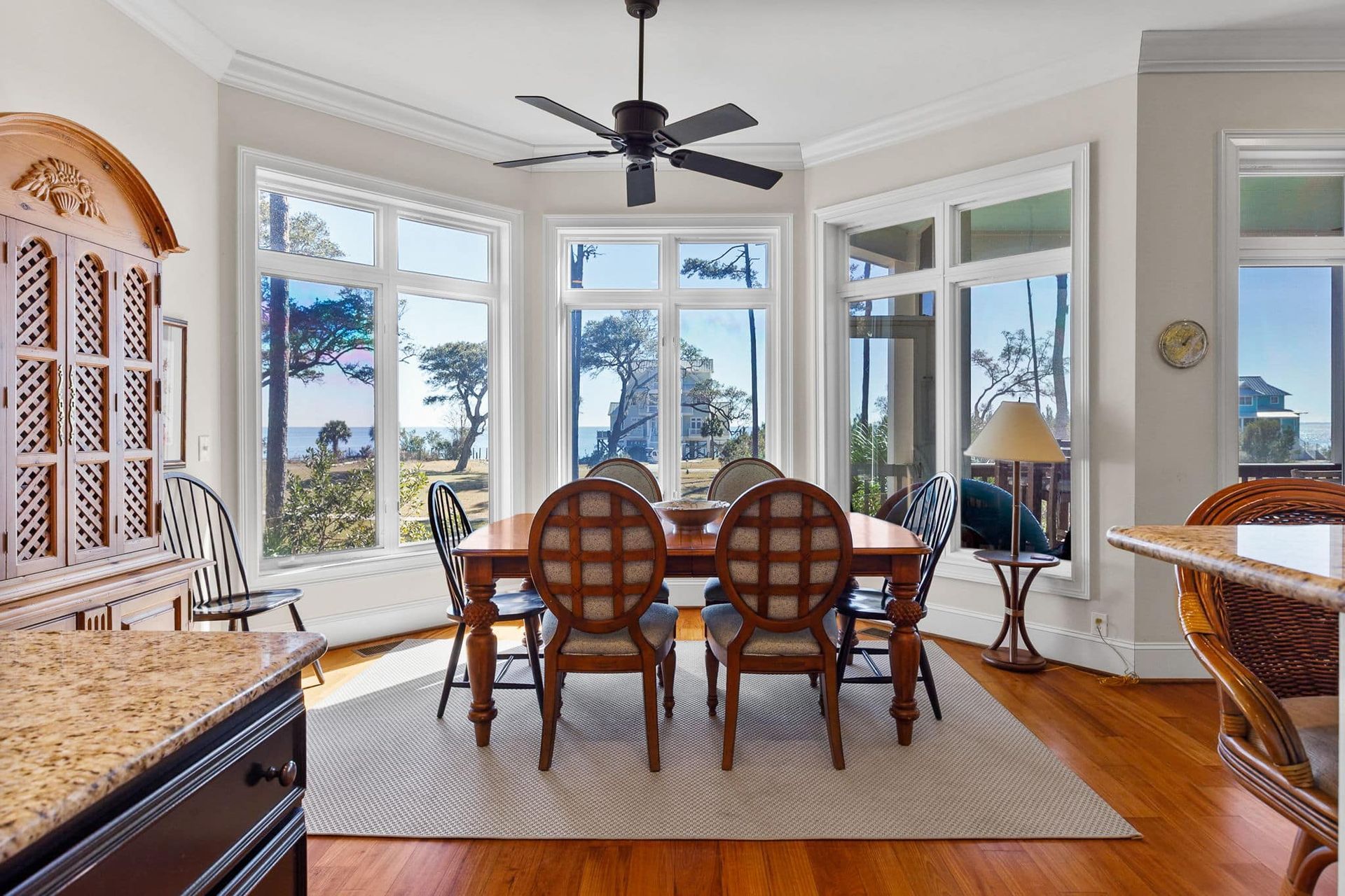 A dining room with a table and chairs and a ceiling fan.