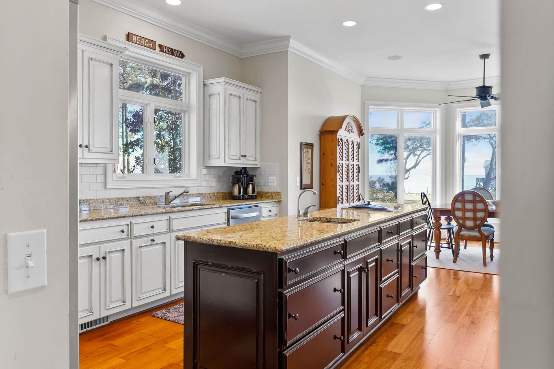 A kitchen with white cabinets and a large island in the middle.
