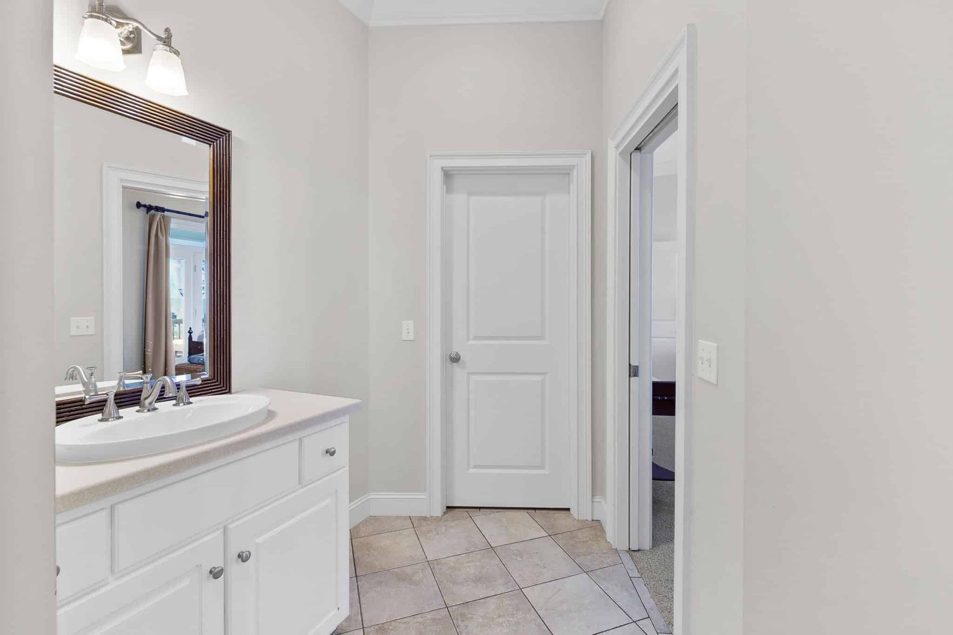 A bathroom with two sinks , a mirror and a tiled floor.