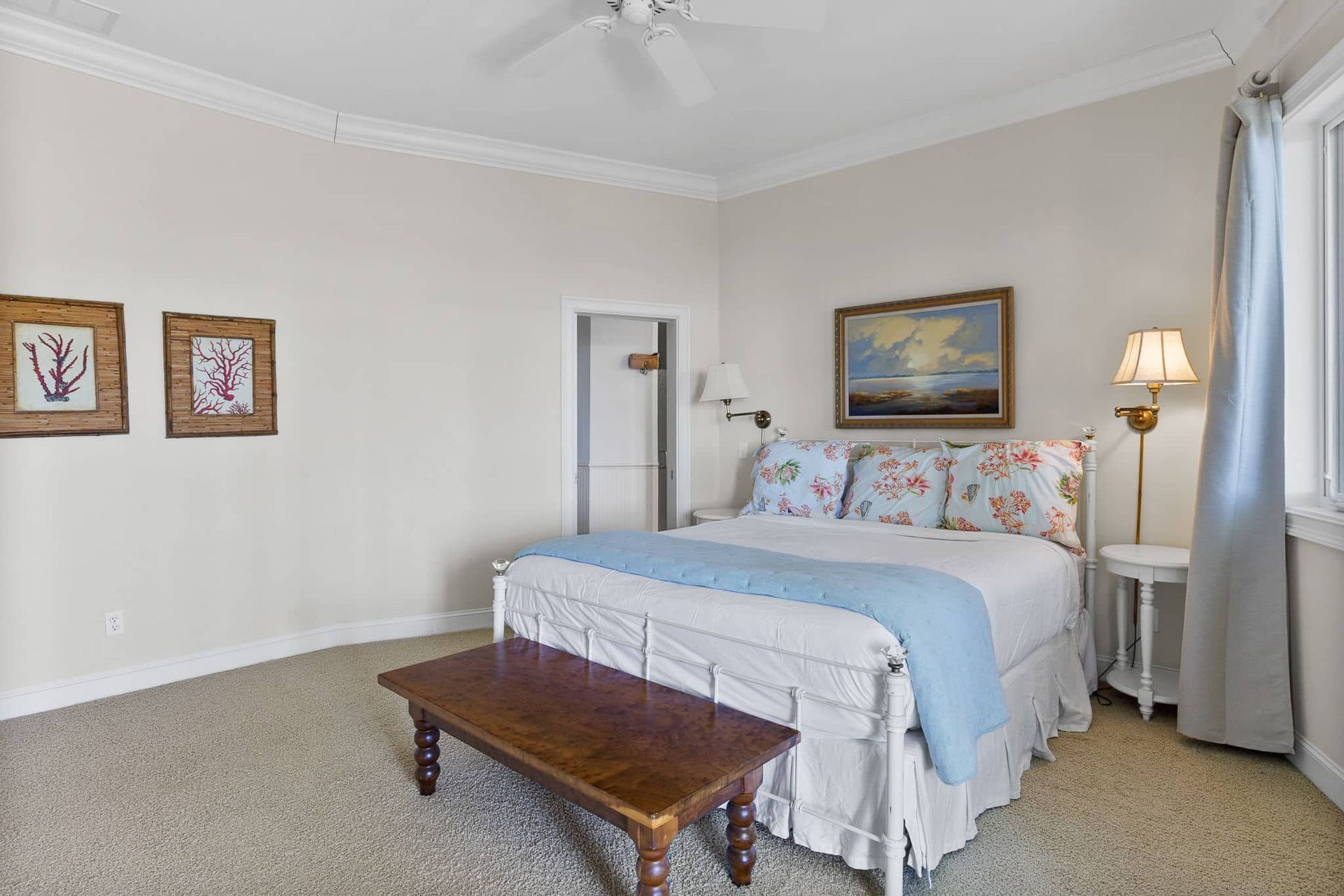 A bedroom with a king size bed and a bench.