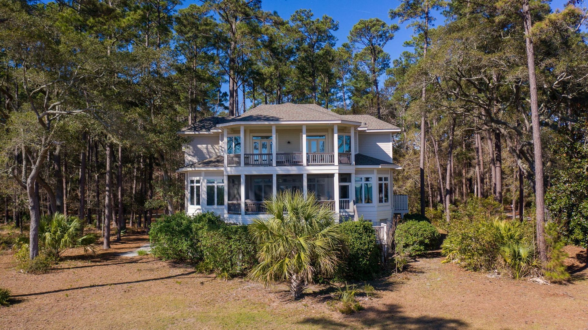An aerial view of a large white house surrounded by trees.