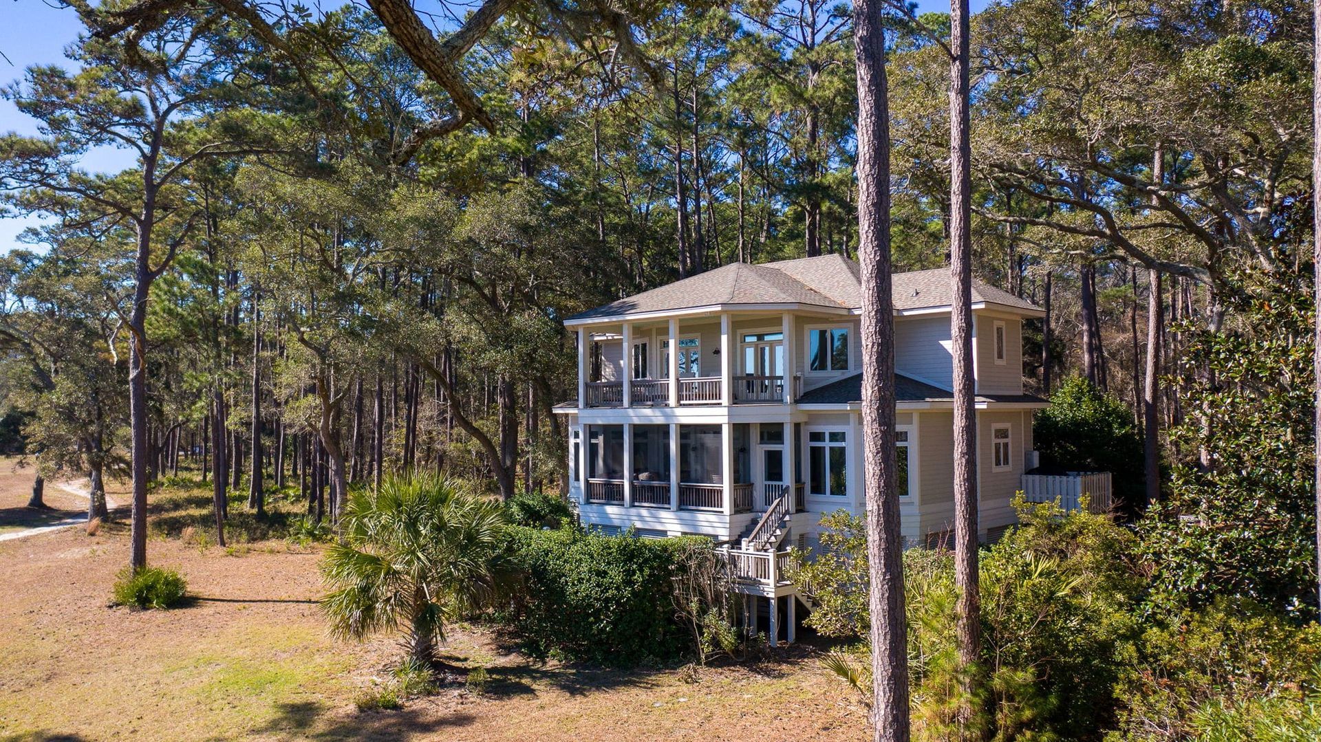 A large house is surrounded by trees in the middle of a forest.