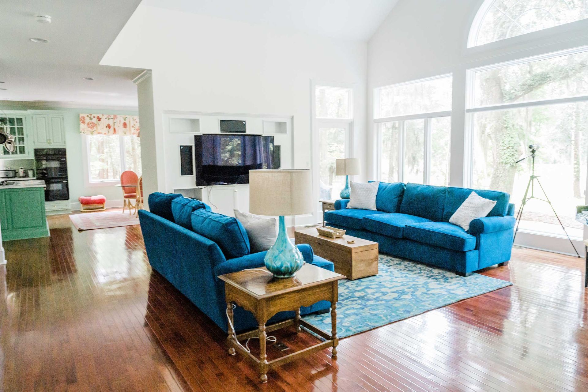 A living room with a blue couch and a blue rug.