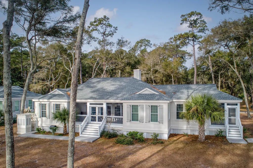 An aerial view of a large white house surrounded by trees.