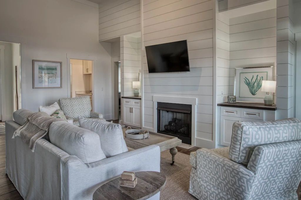 A living room with a couch , chairs , a fireplace and a flat screen tv.