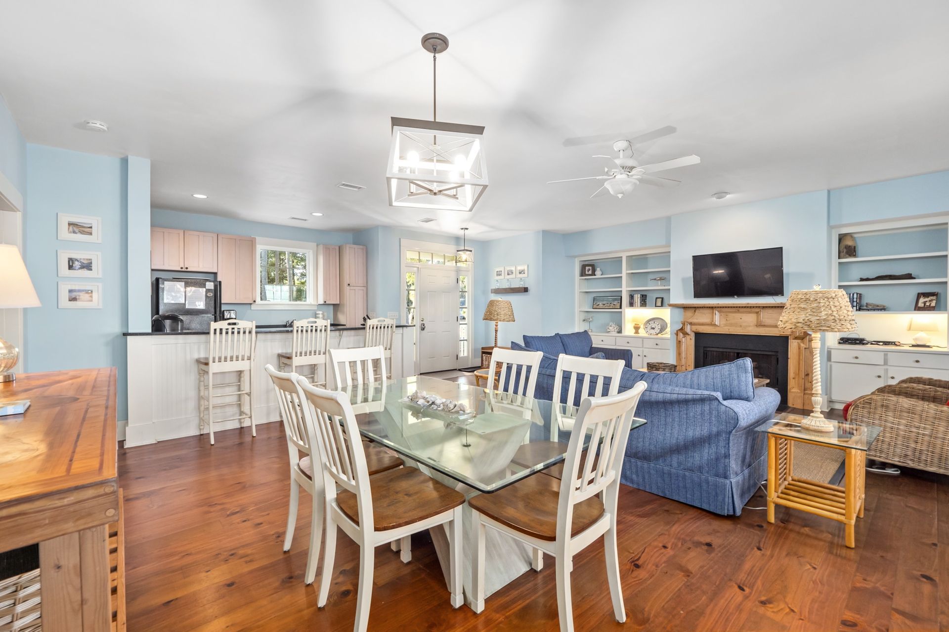 A living room with a dining table and chairs and a fireplace.