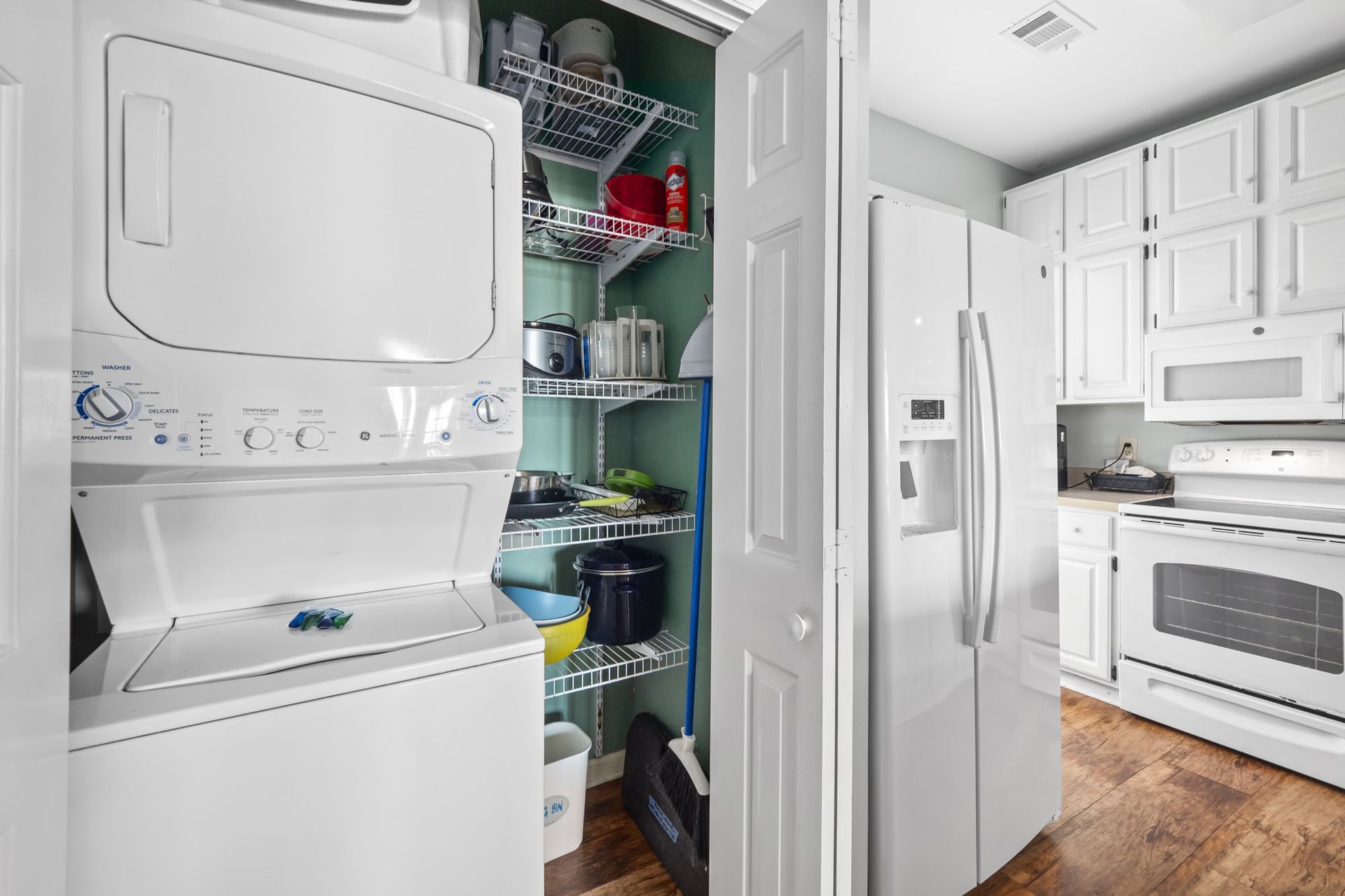 A washer and dryer are stacked on top of each other in a kitchen.