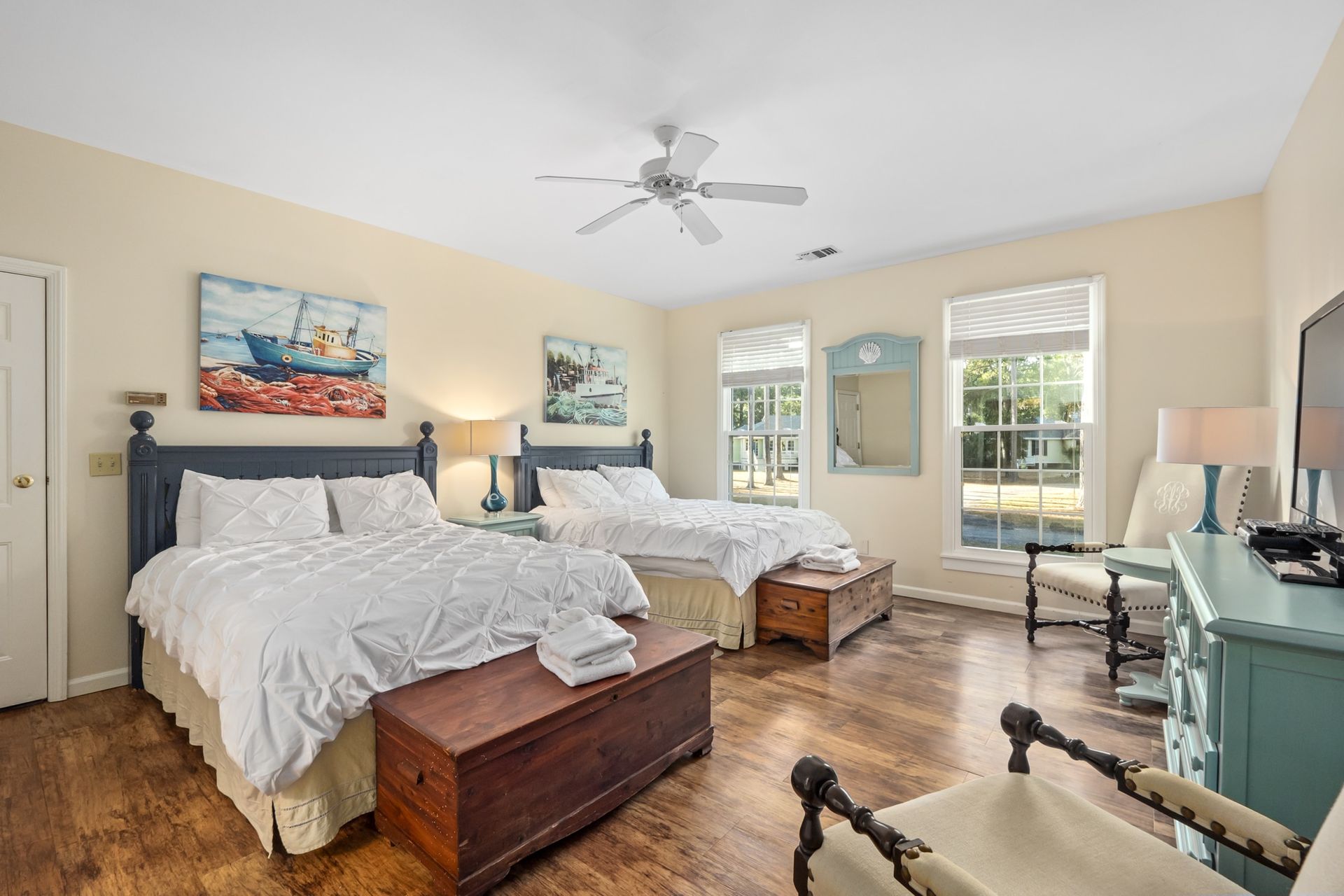 A bedroom with two beds and a ceiling fan.