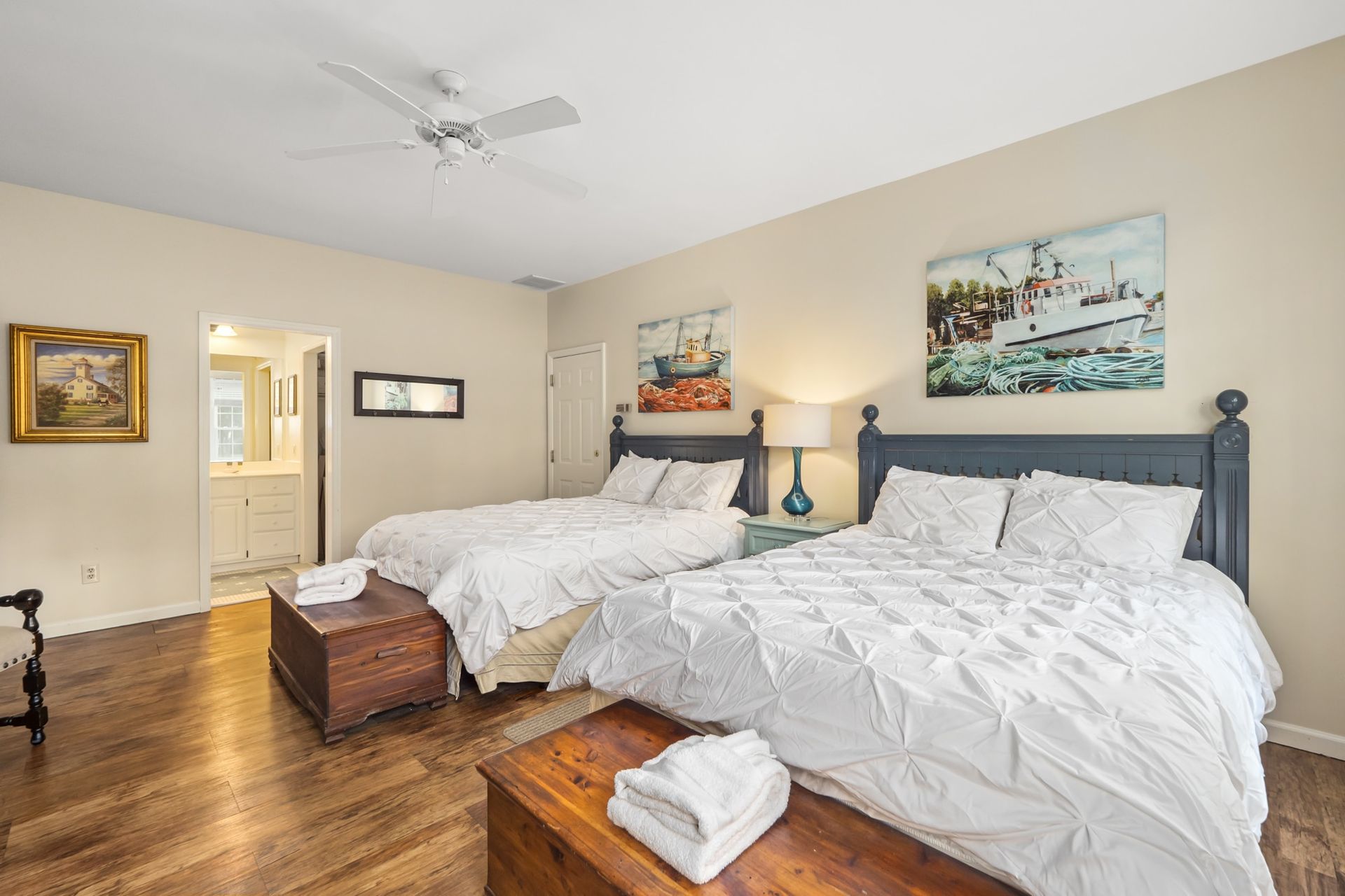 A bedroom with two beds and a ceiling fan.