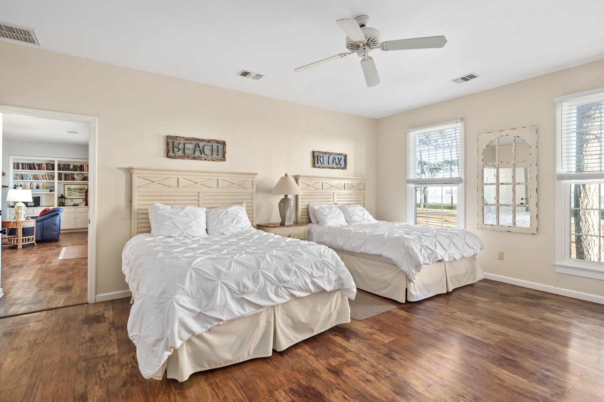 A bedroom with two beds and a ceiling fan.