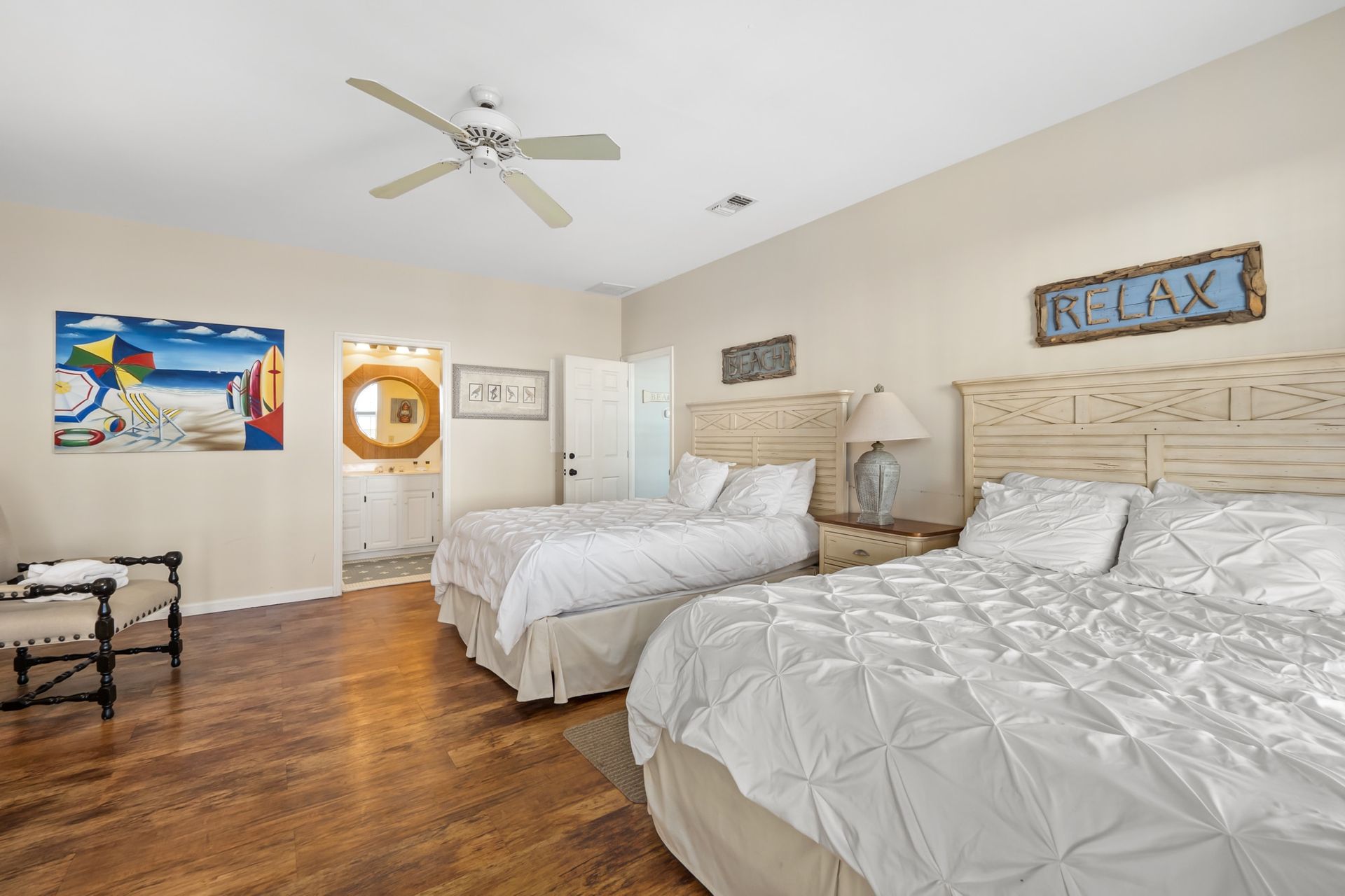 A bedroom with two beds and a ceiling fan.