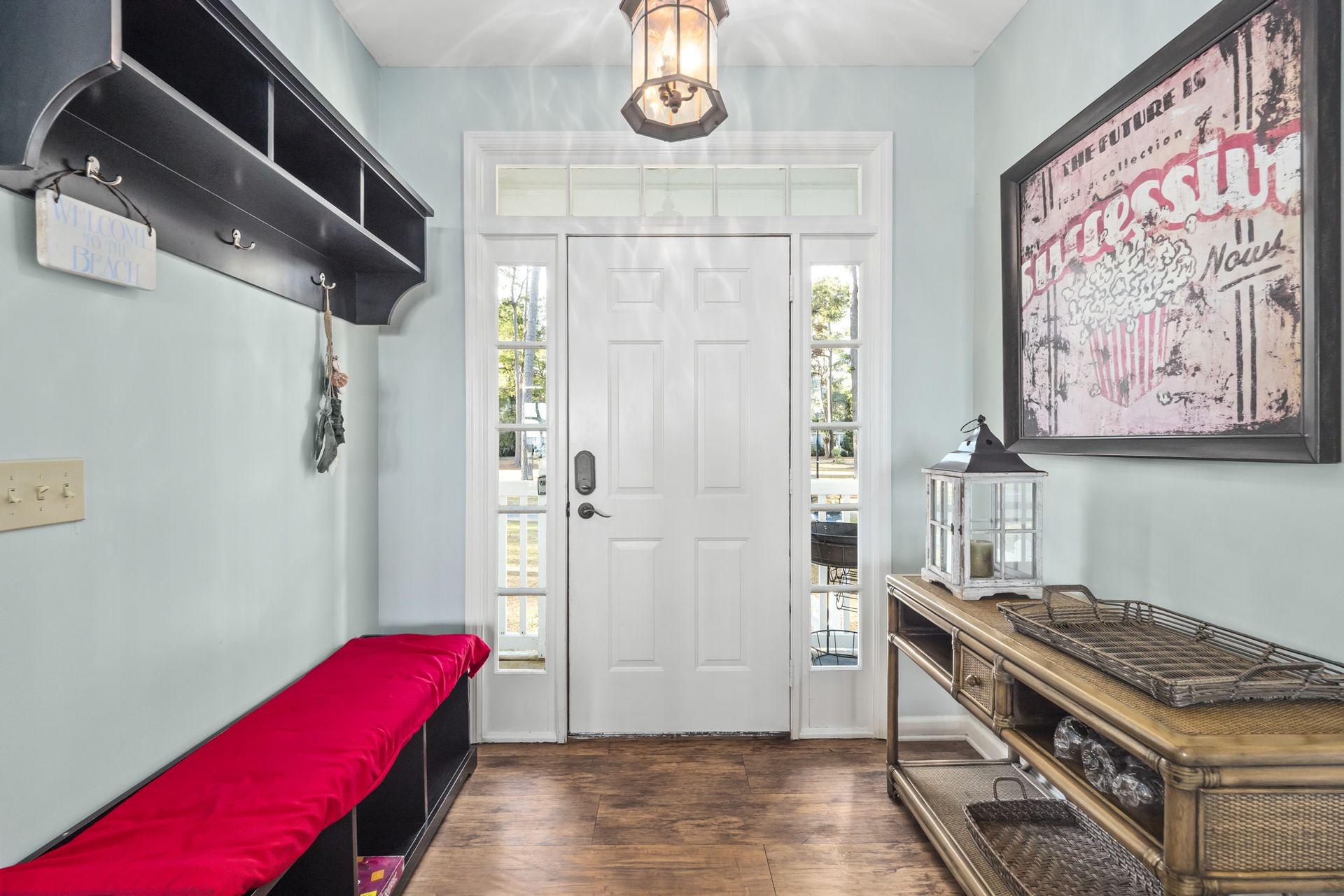 A hallway with a red bench and a picture on the wall.