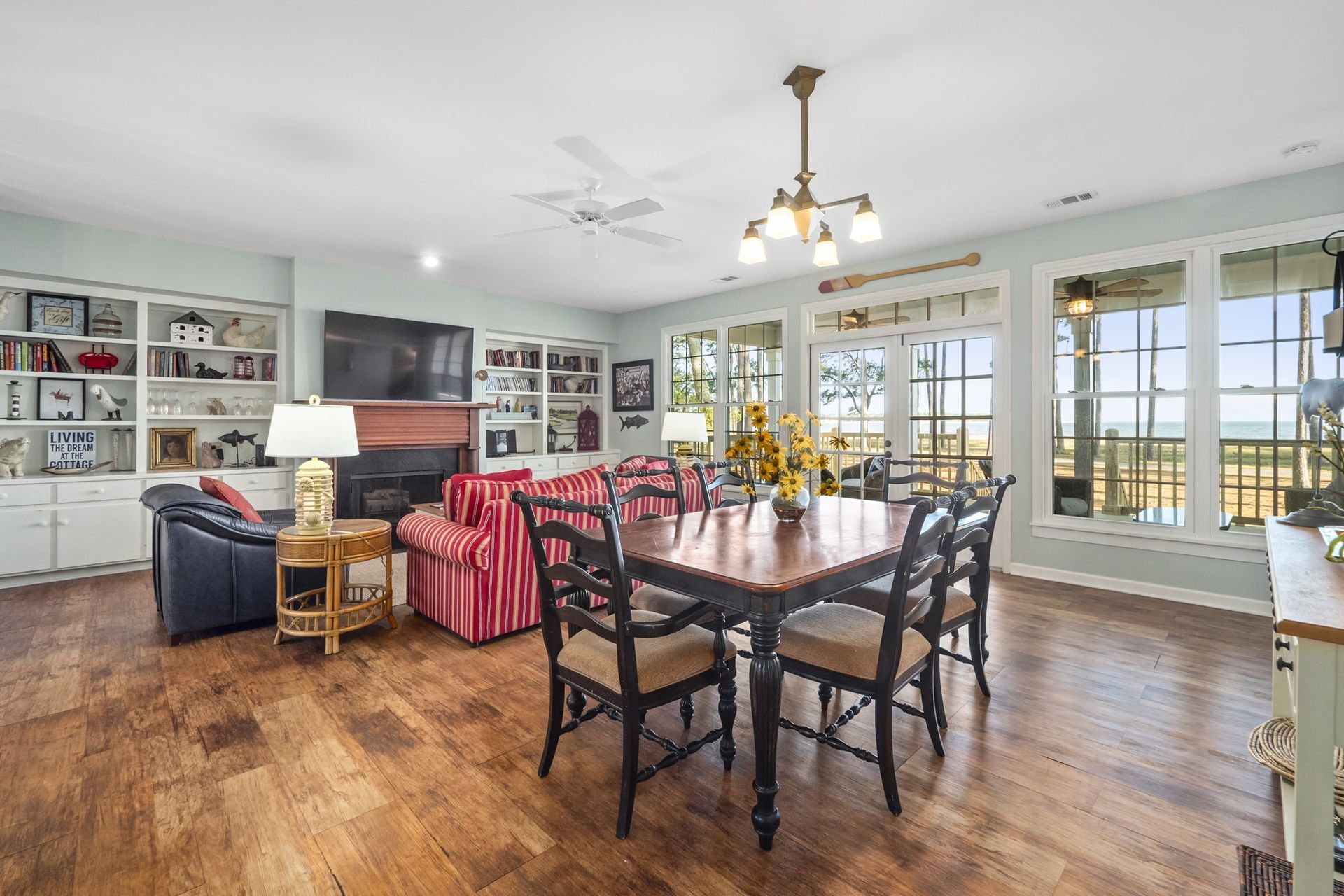 A living room with a dining table and chairs and a fireplace.
