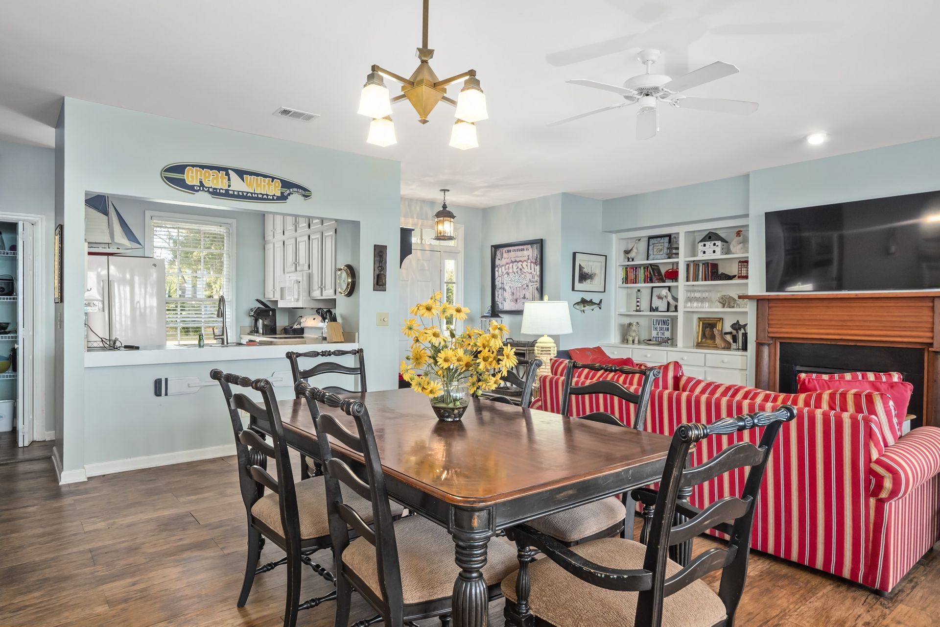 A living room with a dining table and chairs and a fireplace.