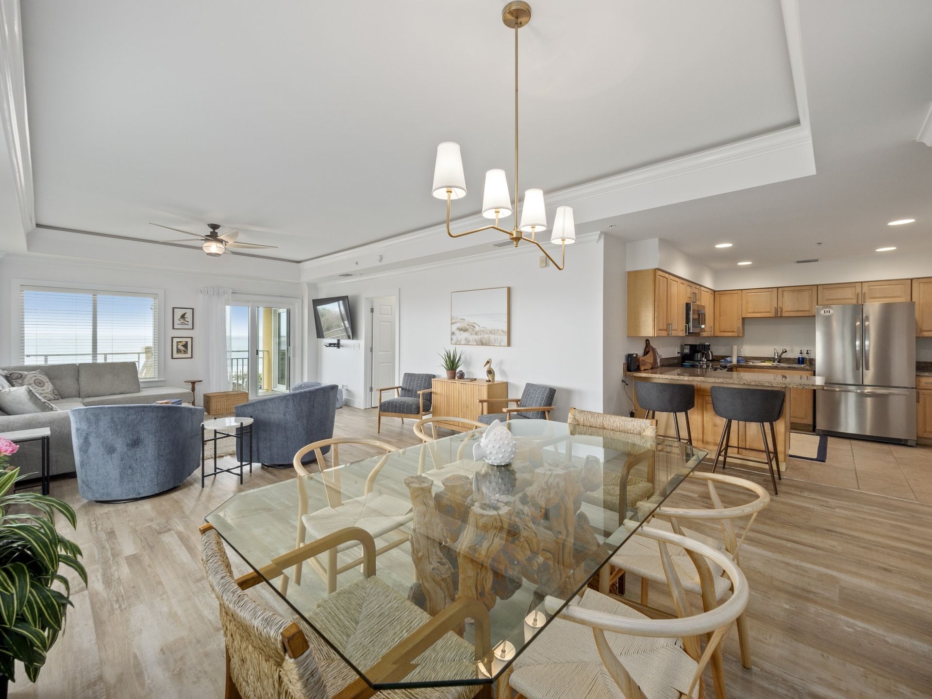 A living room with a dining table and chairs and a kitchen.