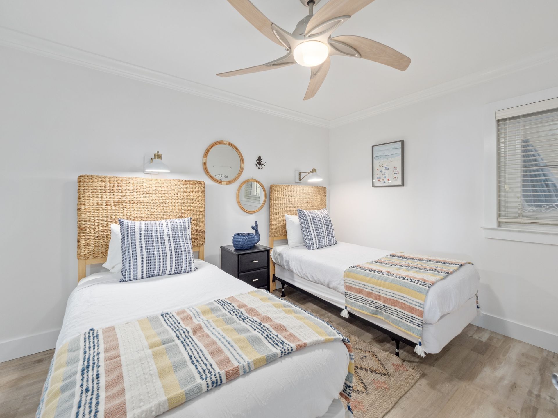 A bedroom with two twin beds and a ceiling fan.