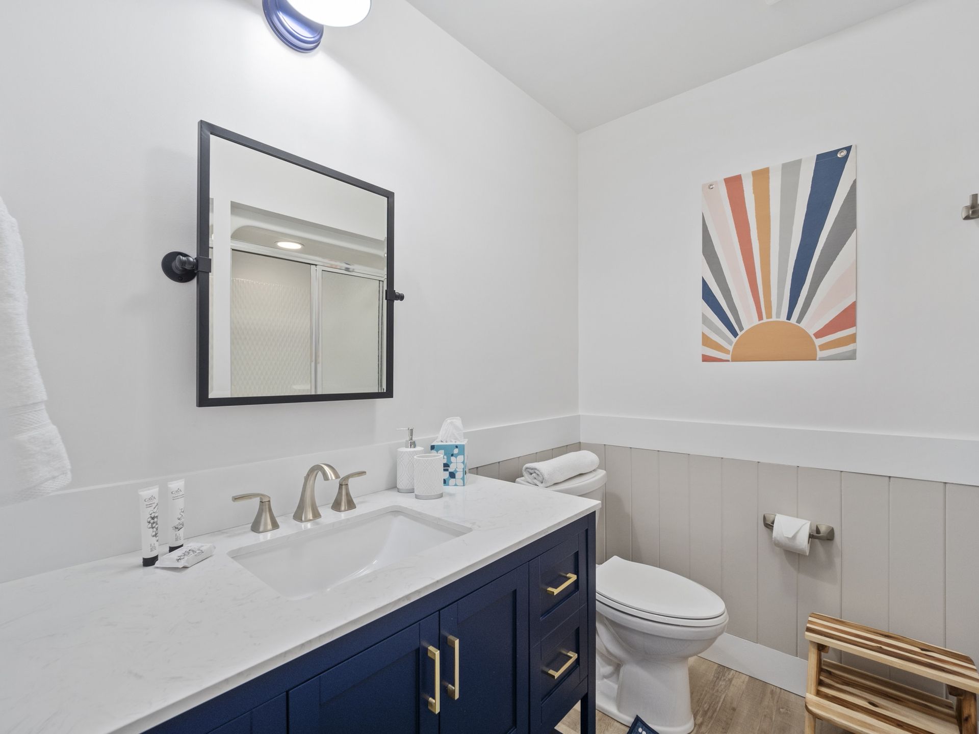 A bathroom with a sink , toilet and mirror.