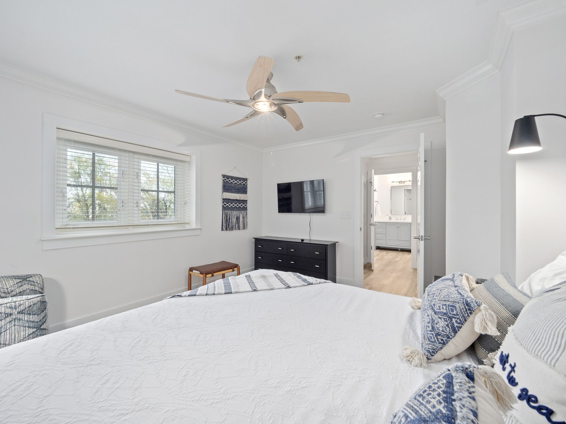 A bedroom with a large bed and a ceiling fan.