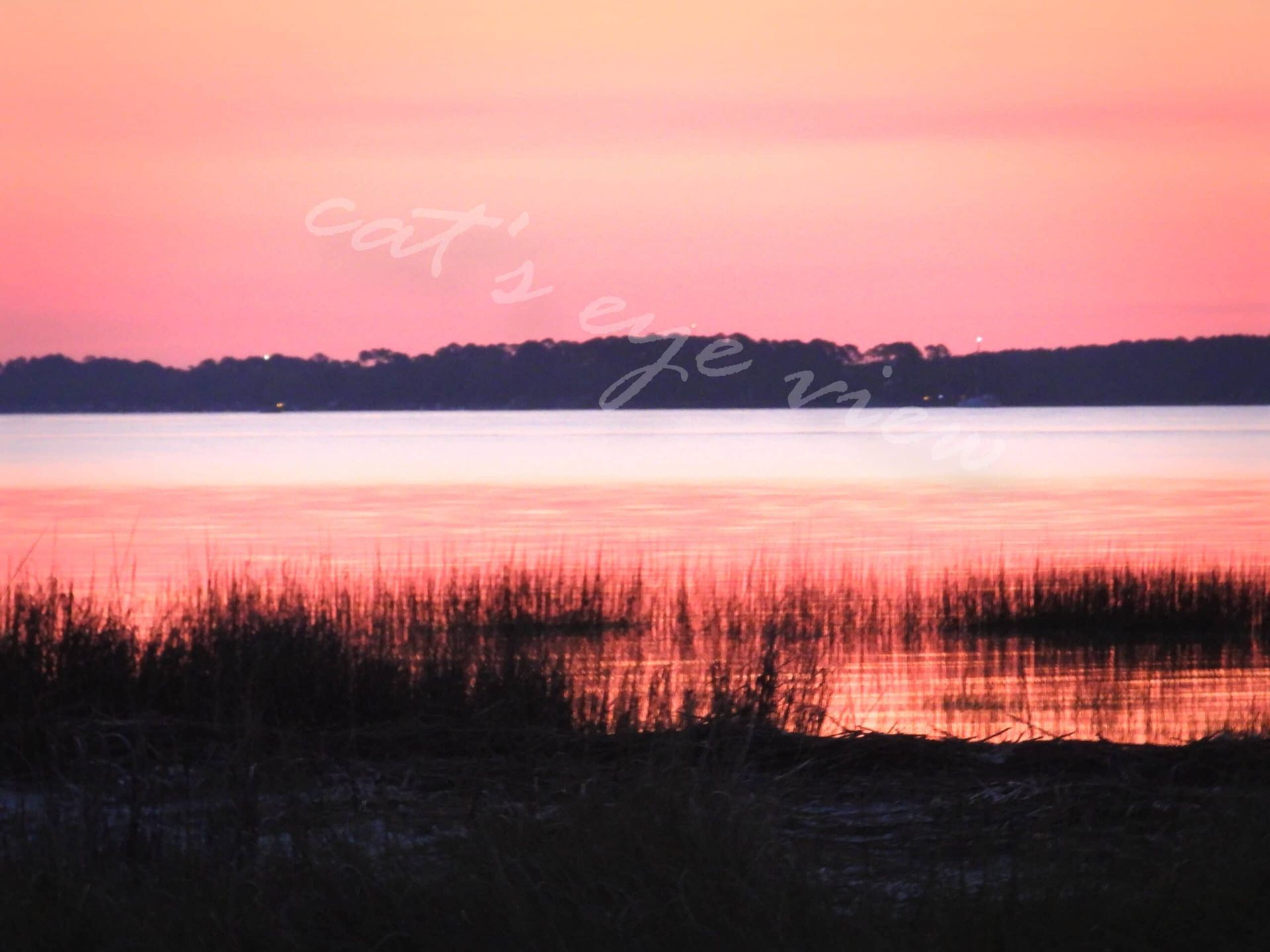 A sunset over a body of water with the words cat 's eye on the bottom