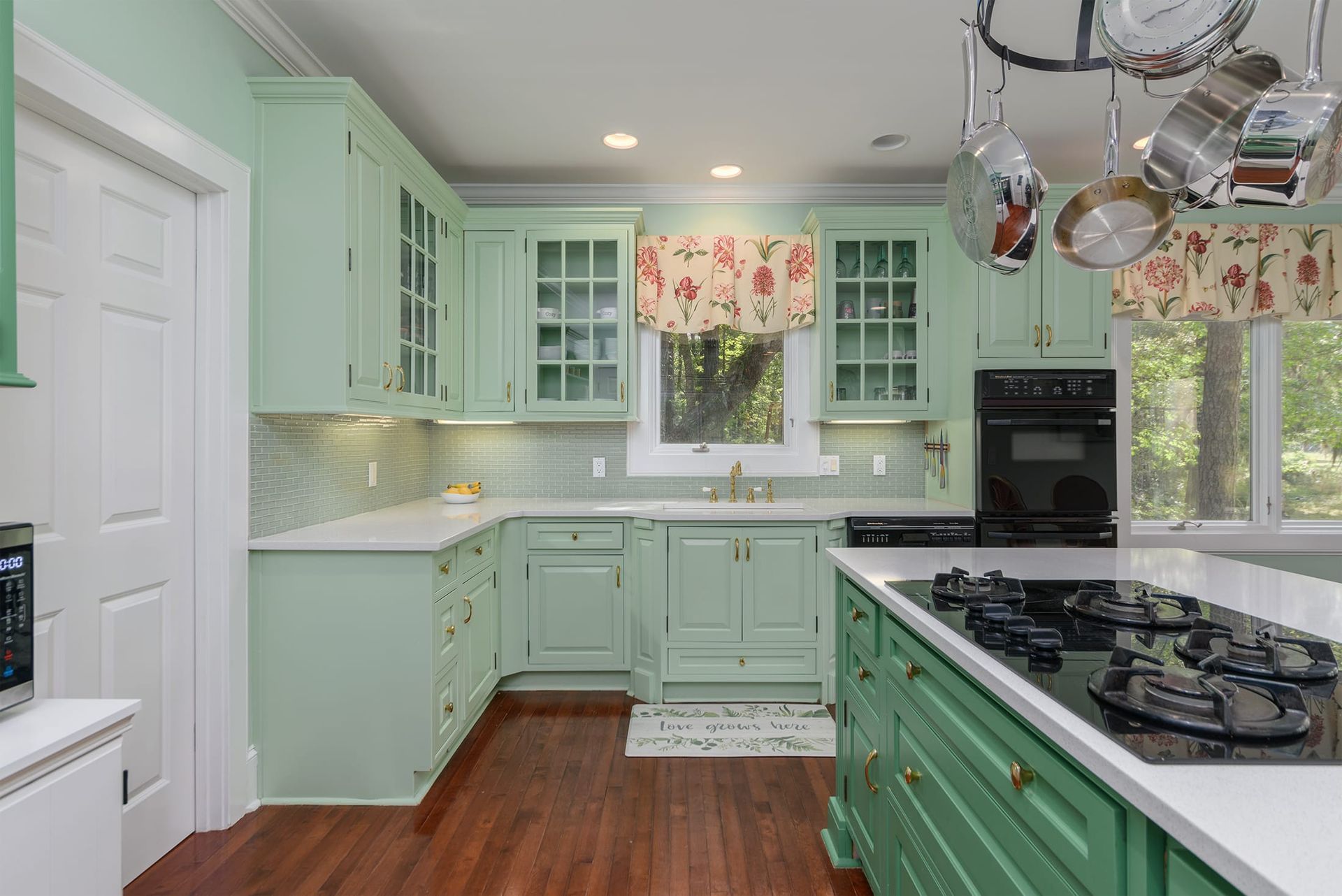 A kitchen with green cabinets and a stove top oven