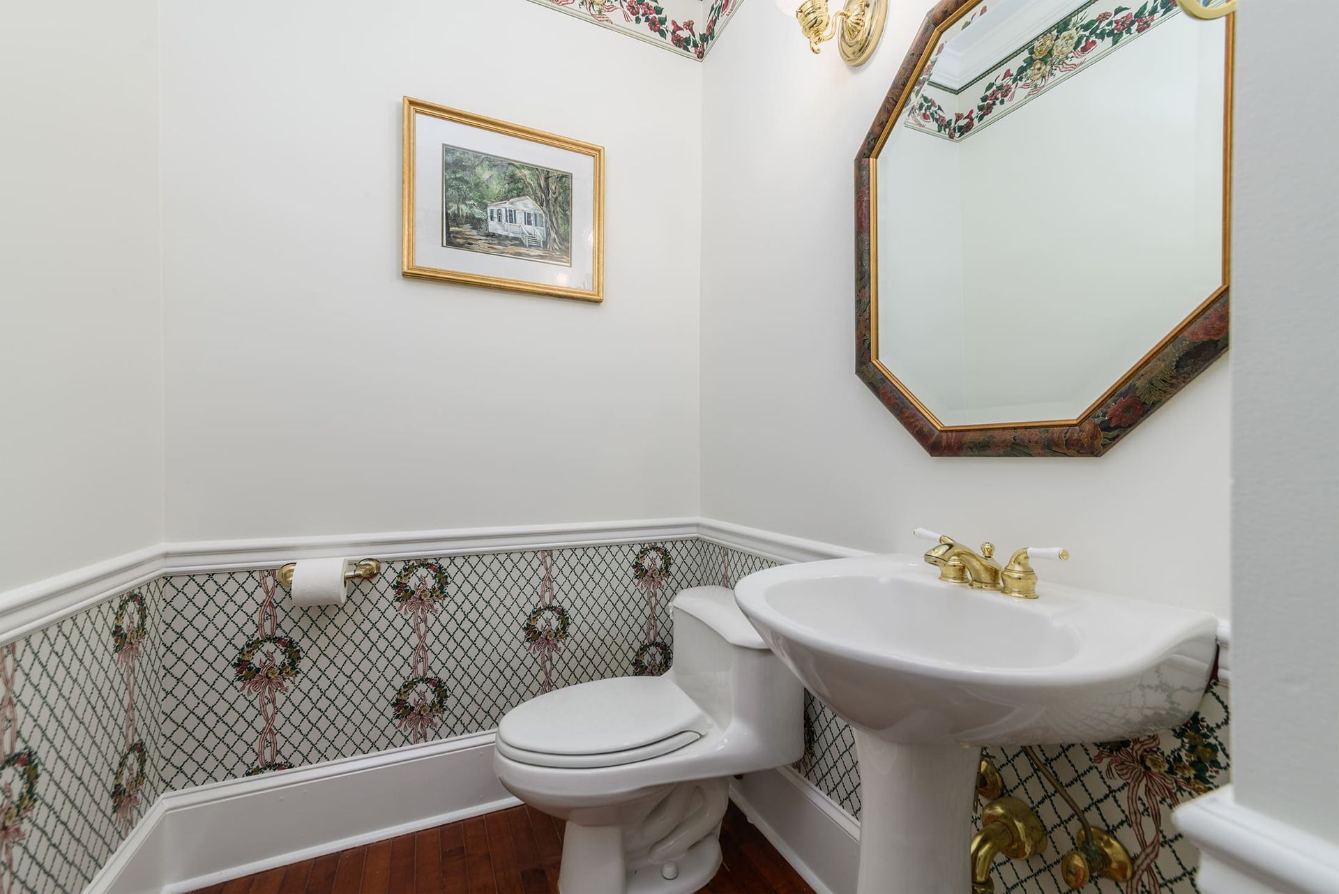 A bathroom with a toilet , sink and mirror.