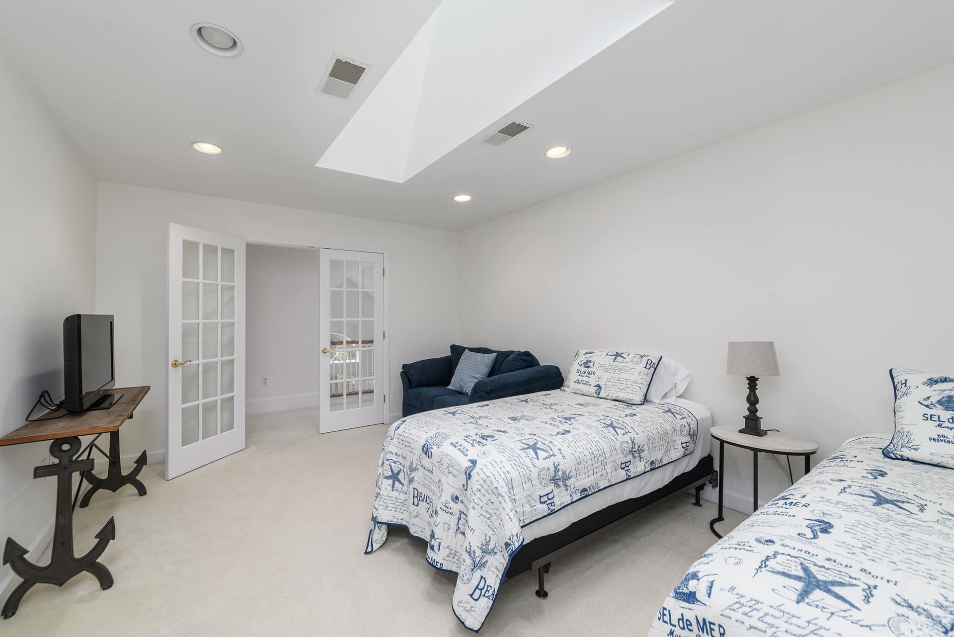 A bedroom with two beds , a couch and a television.