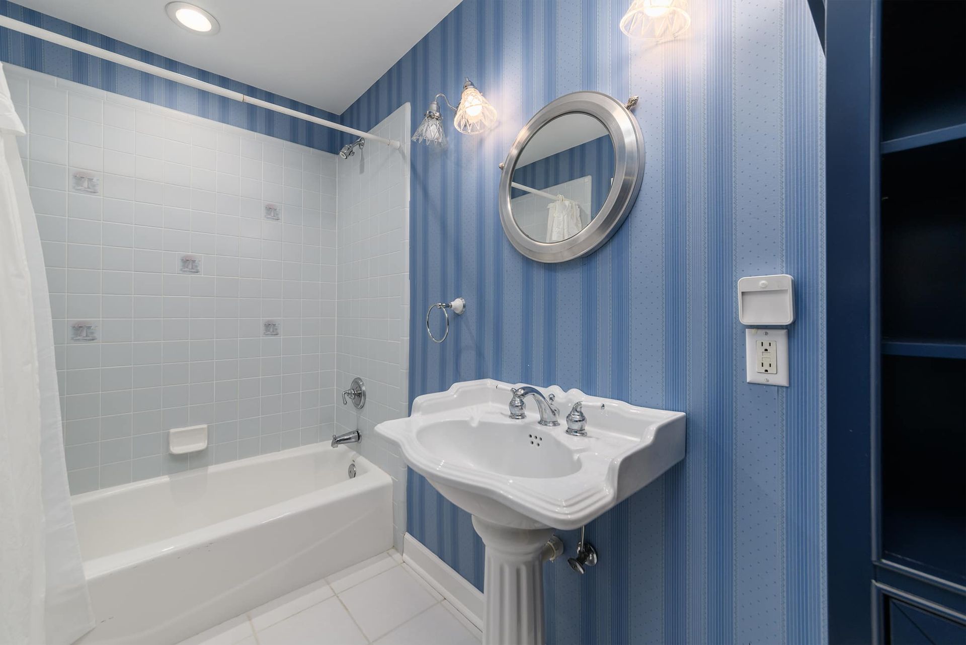 A bathroom with a sink , tub and mirror