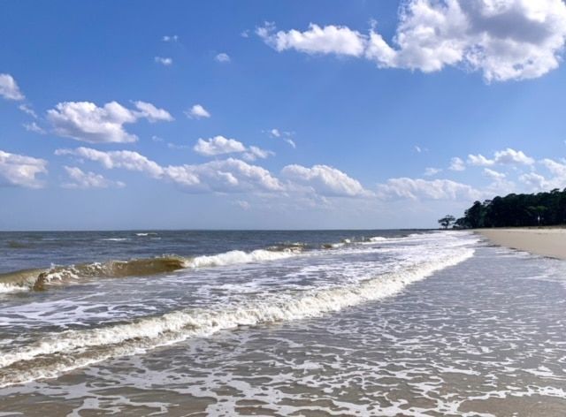A beach with waves coming in on a sunny day