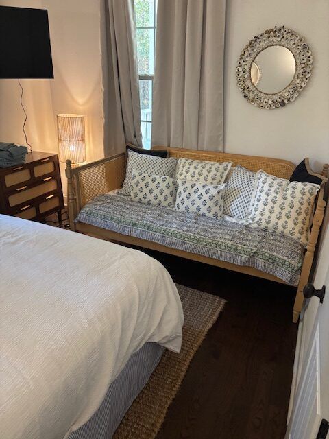 A bedroom with a couch and a mirror on the wall