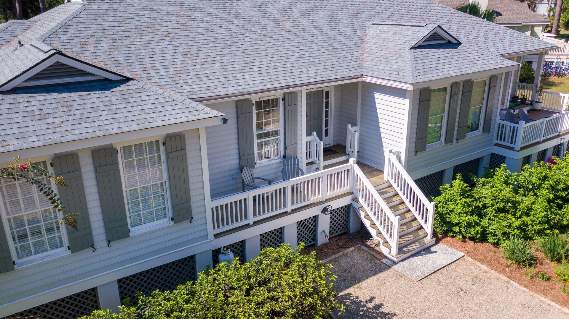 An aerial view of a large white house with a gray roof.