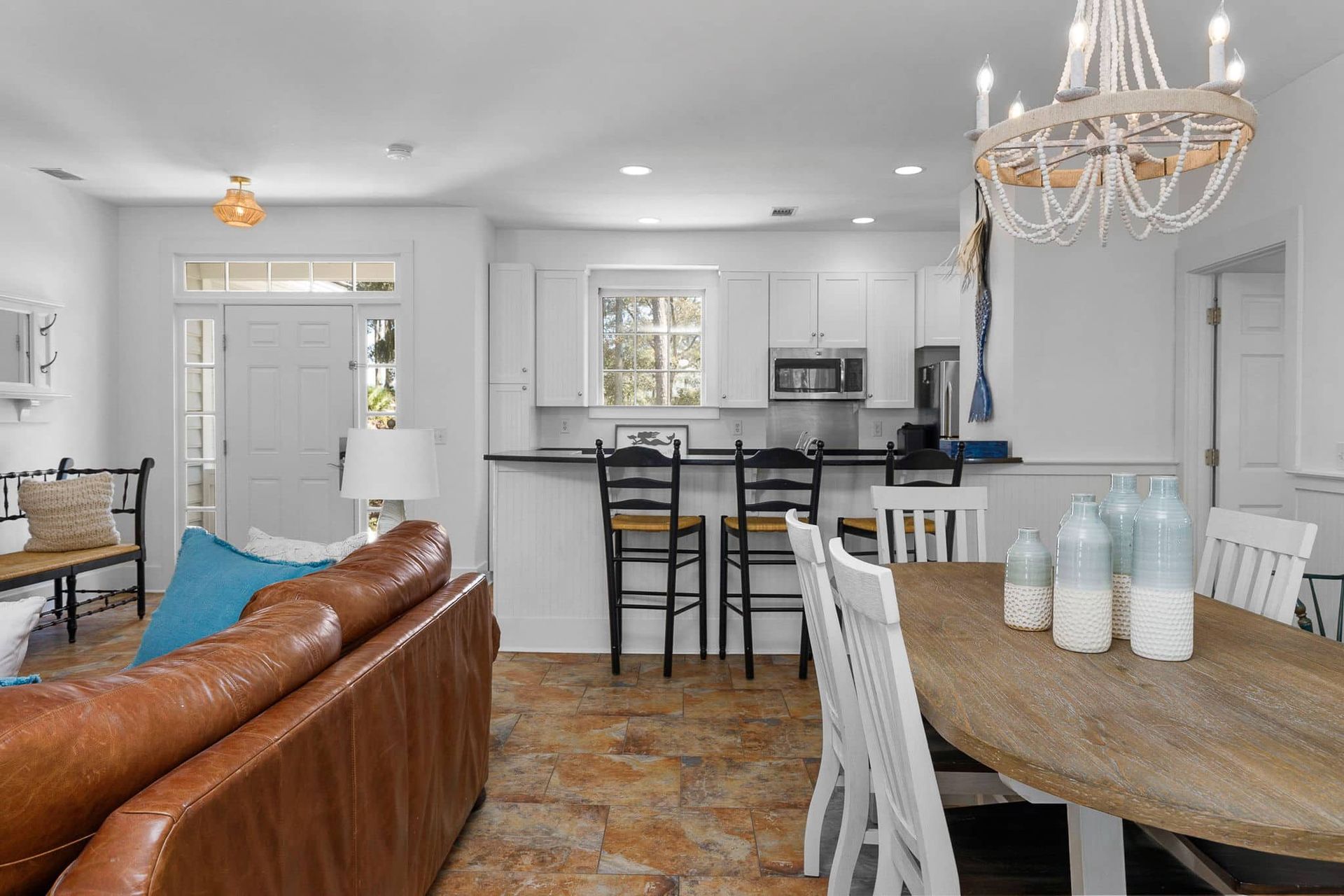 A living room with a couch , table , chairs and a chandelier.