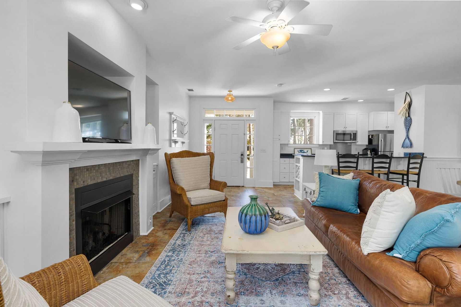 A living room with a couch , chairs , coffee table and fireplace.