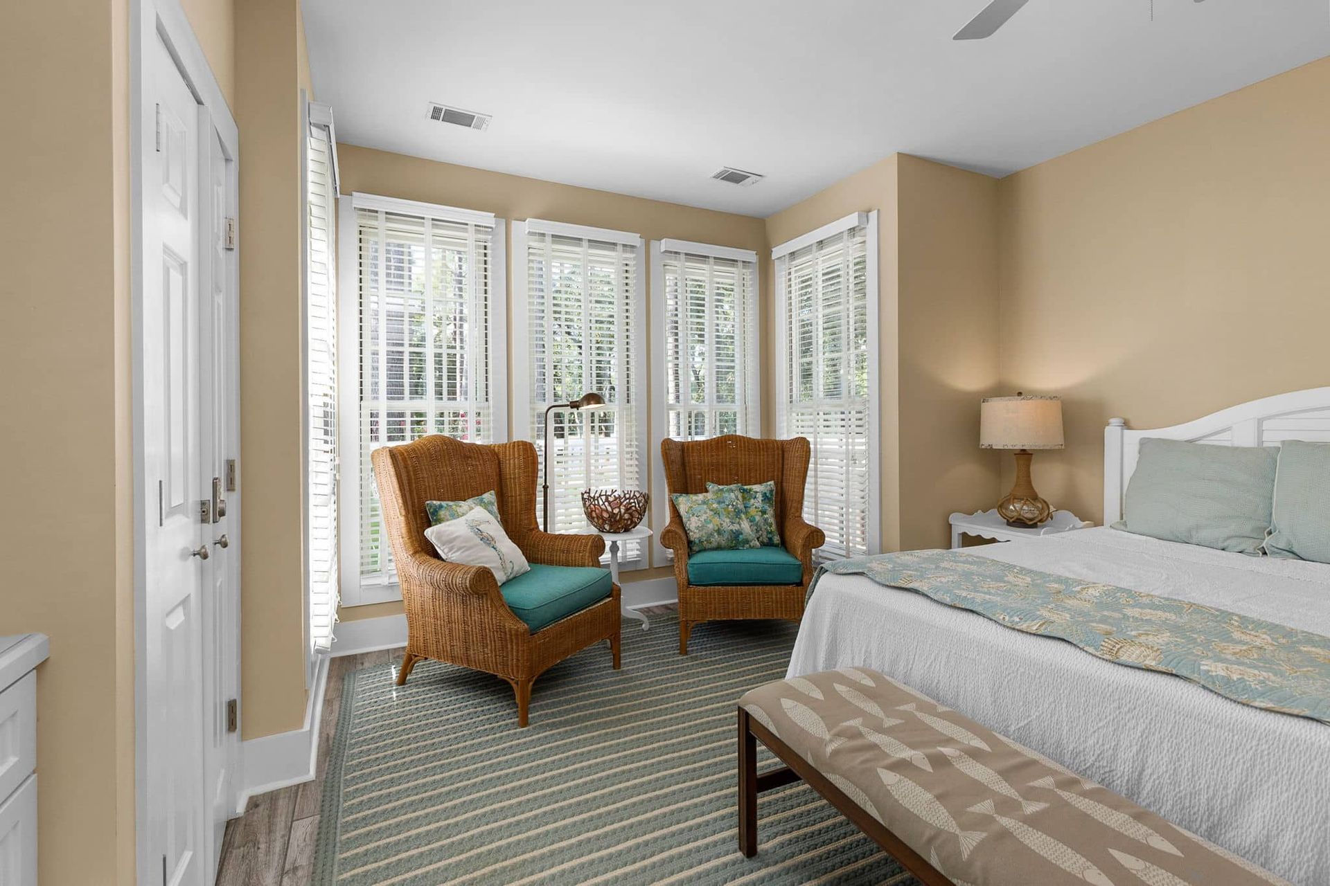 A bedroom with a king size bed , two chairs , and a bench.