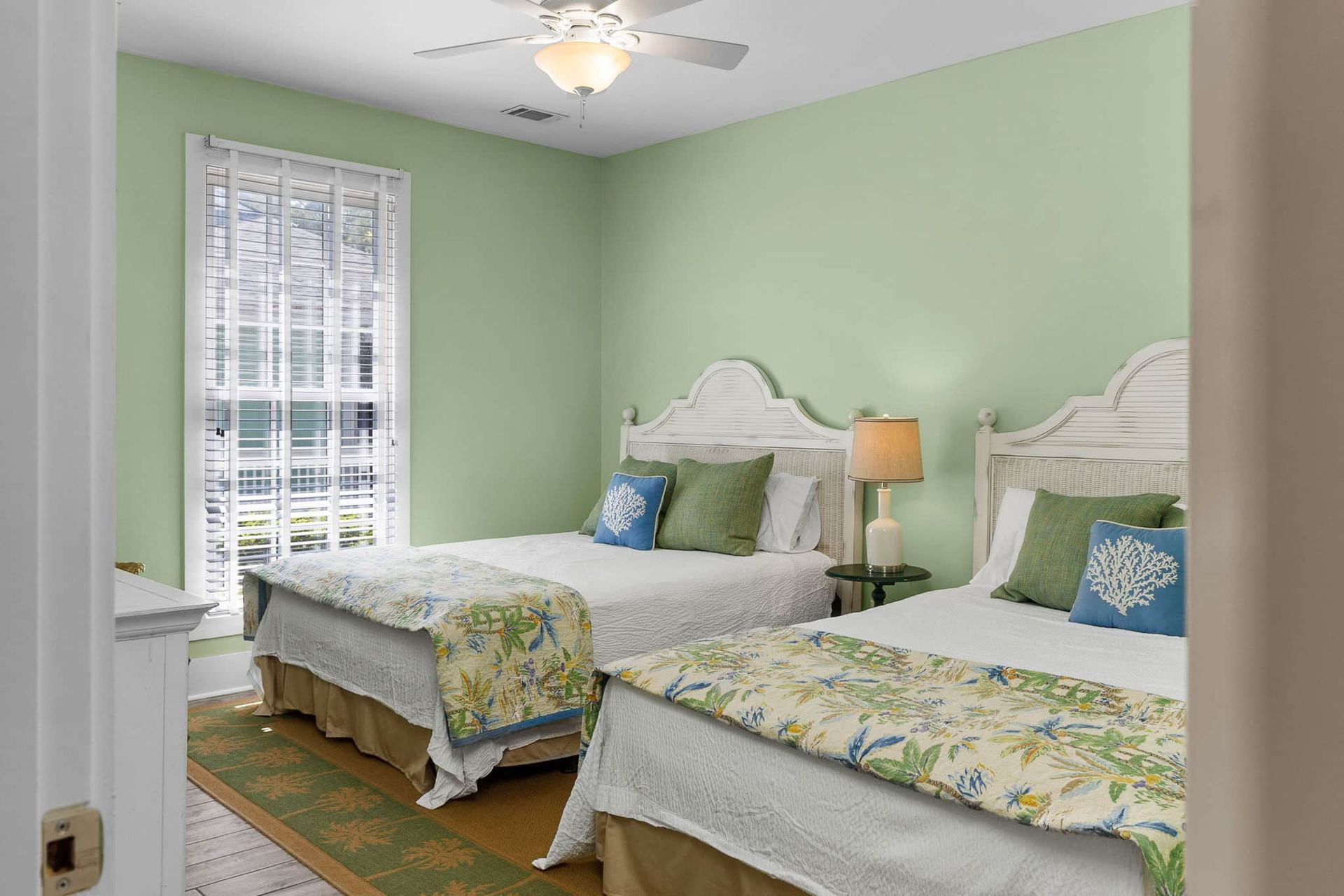 A bedroom with two beds and a ceiling fan.