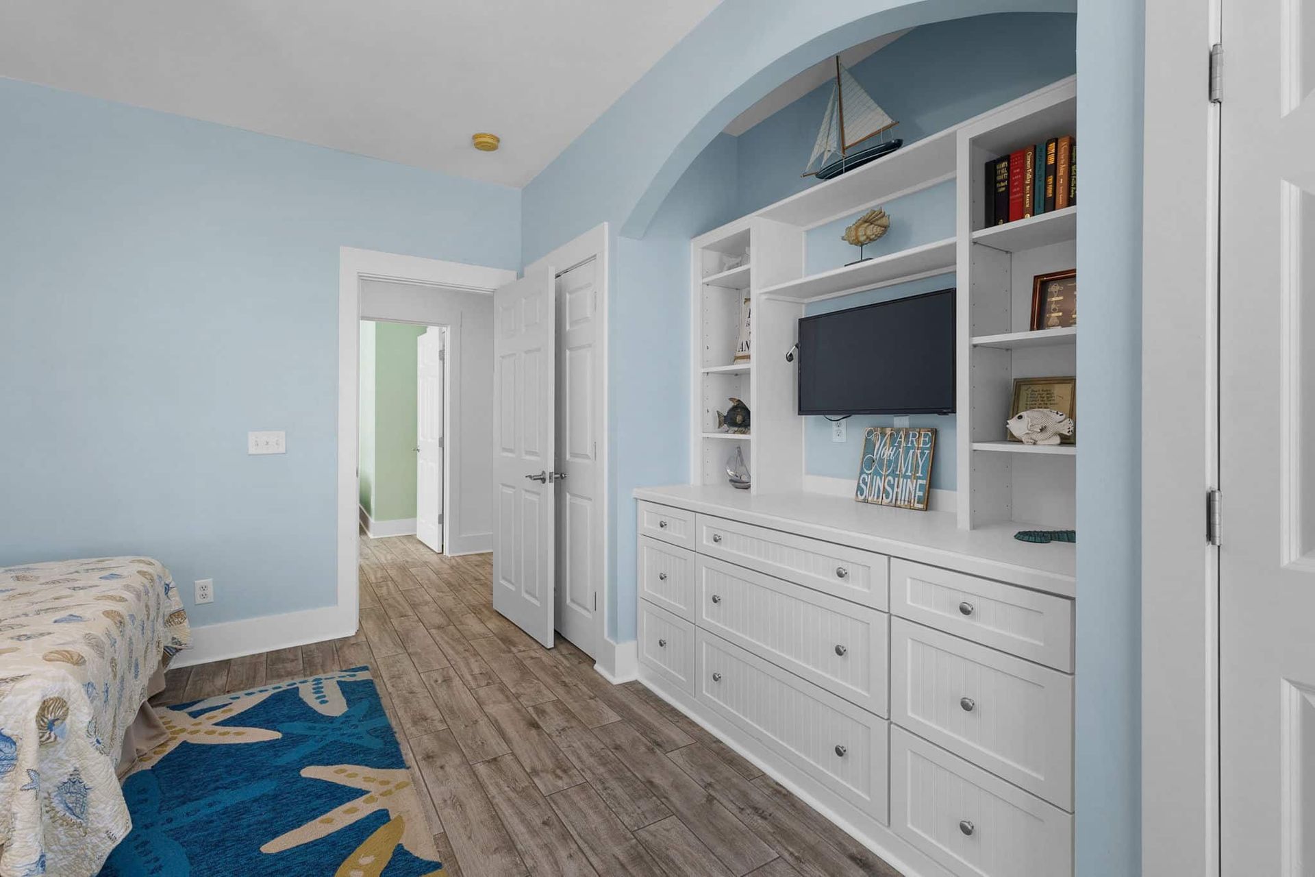 A bedroom with a bed , dresser , and television.